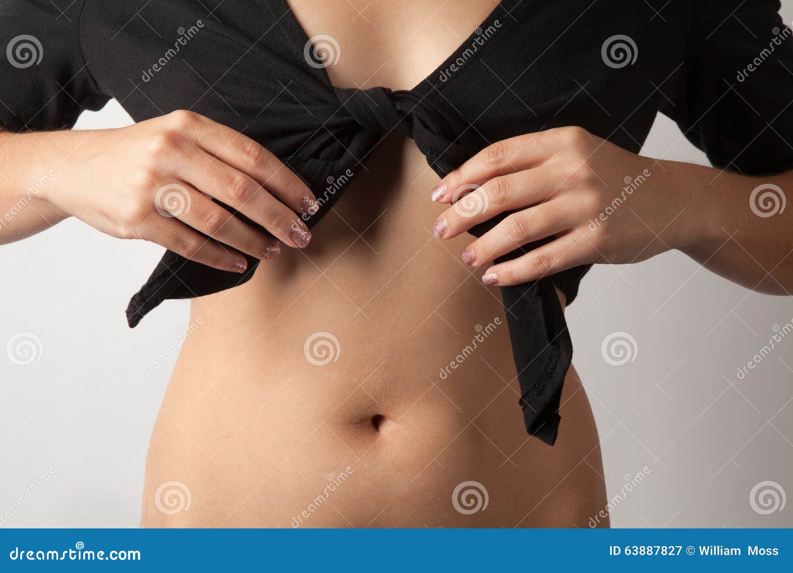 anonymous woman tying crop top