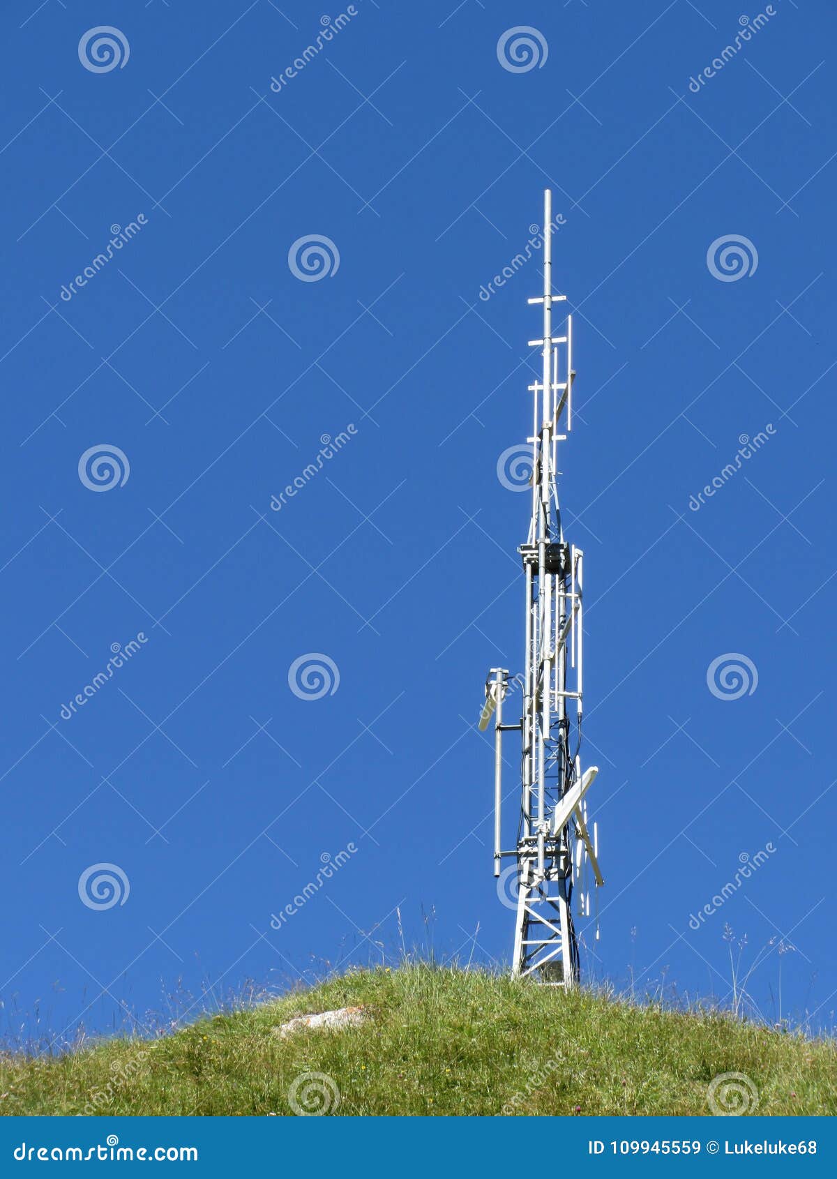 Antenna on the Top of the Mountain Against the Blue Sky and Green