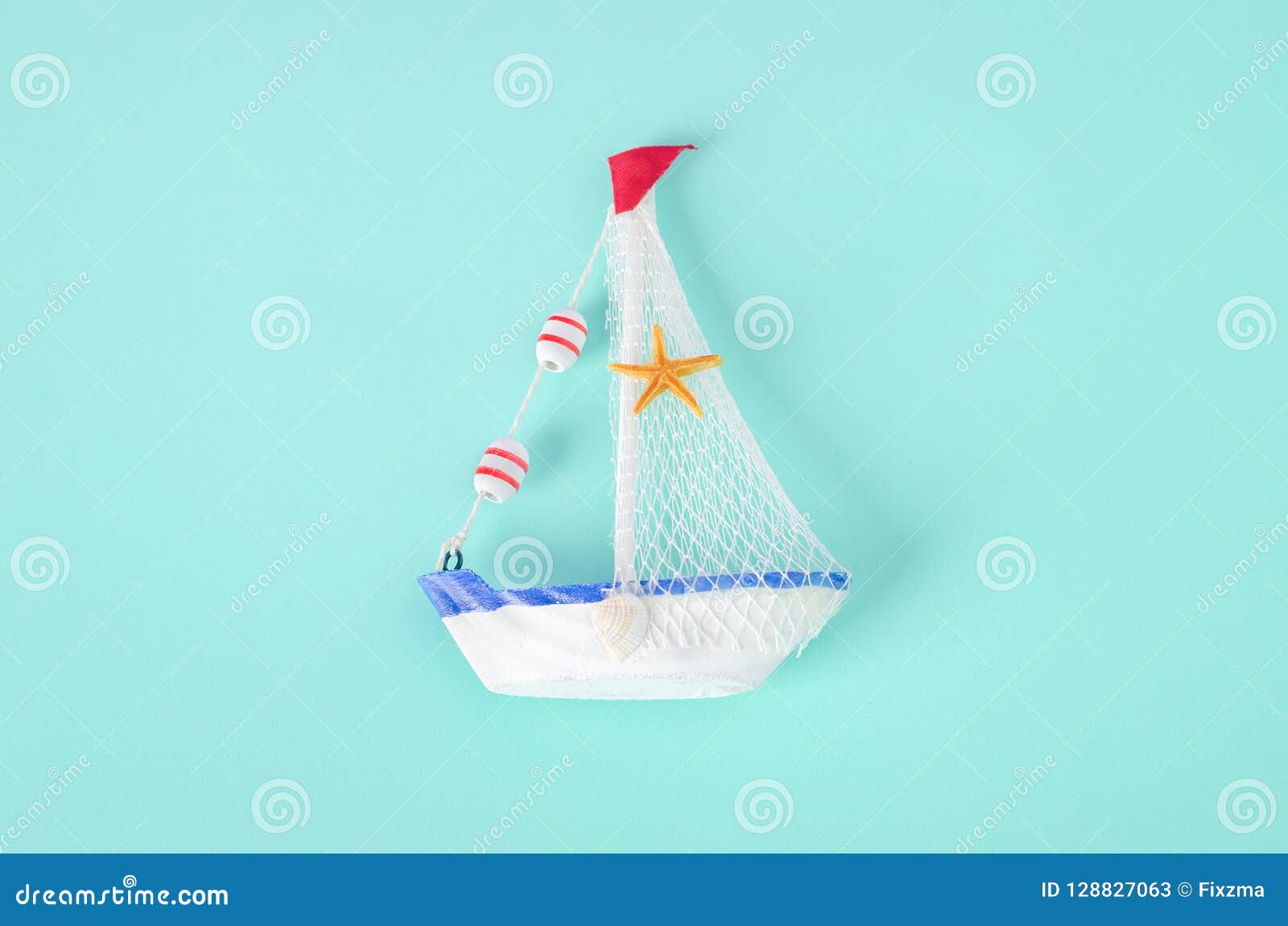 Antikviteten seglar fartygleksakmodellen med repet och snäckskalet på vit och. Antikviteten seglar fartygleksakmodellen med repet och snäckskalet på vit- och blåttbakgrund - nautisk bakgrund