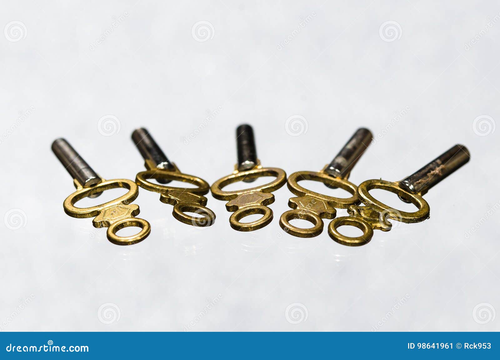 Antique Brass Pocket Watch Keys Laying on White Surface Stock Image