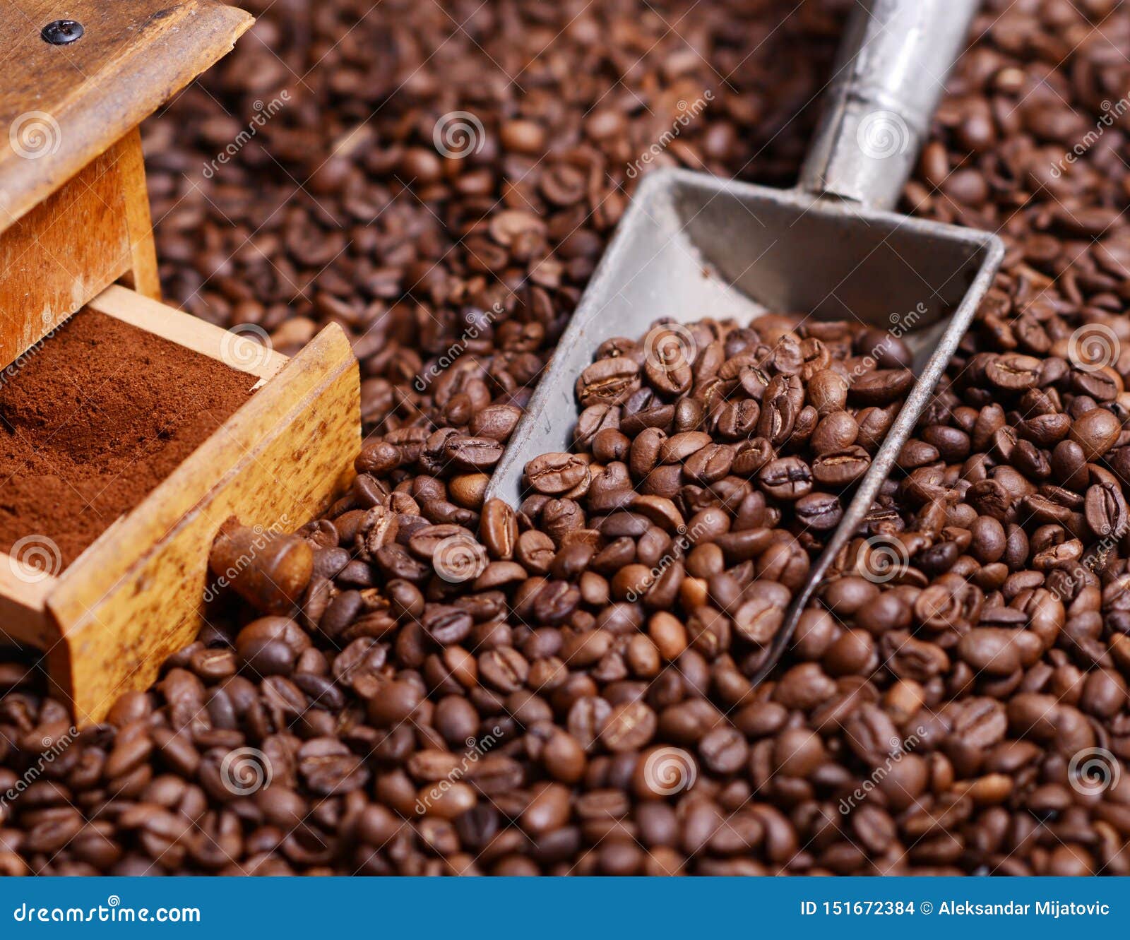 Antique Coffee Grinder with Grinded Coffee in Scoop on Beans Stock