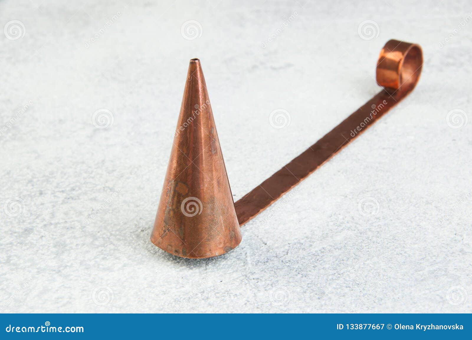 antique copper candle snuffer on concrete background