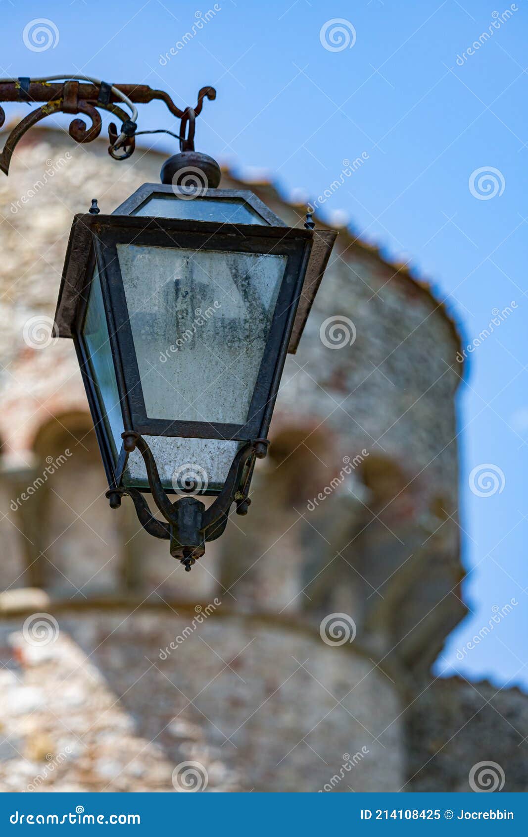 antique street lamp in front of stone like castle building