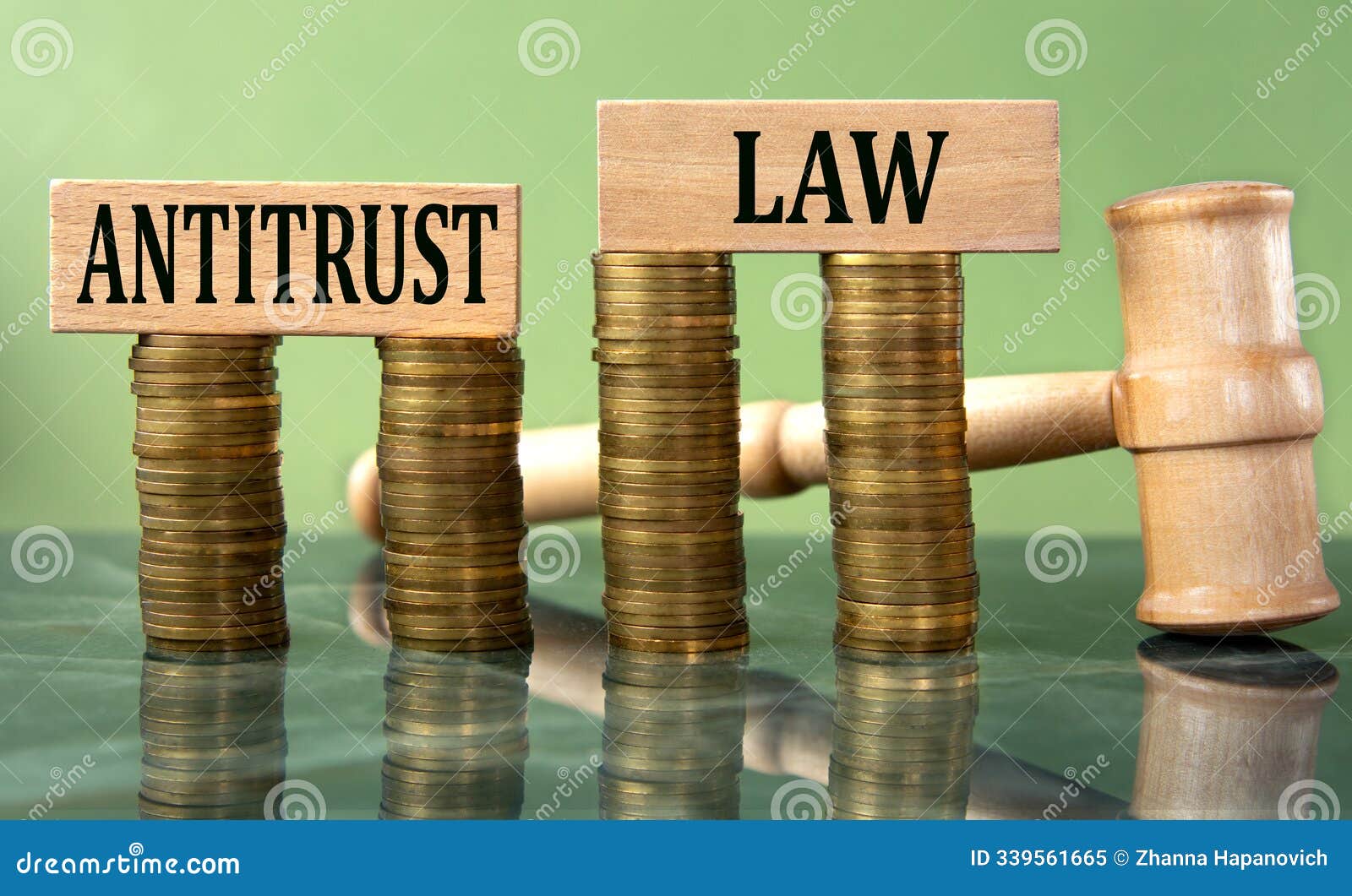 antitrust law - words on a white sheet with a judge's gavel and a stack of coins in the background