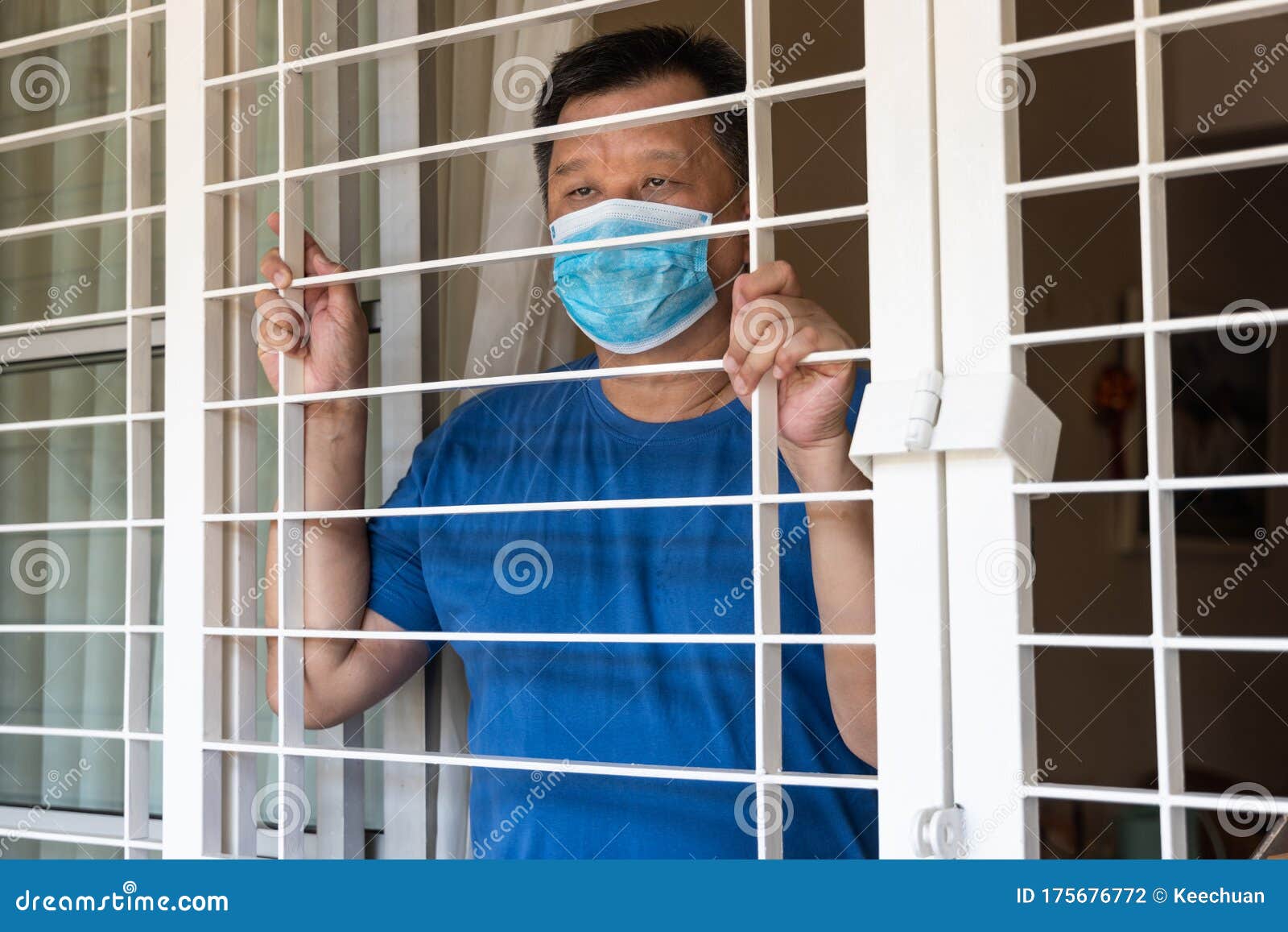 anxious chinese man with face mask self isolate quarantine at home for fear of contact covid-19 virus