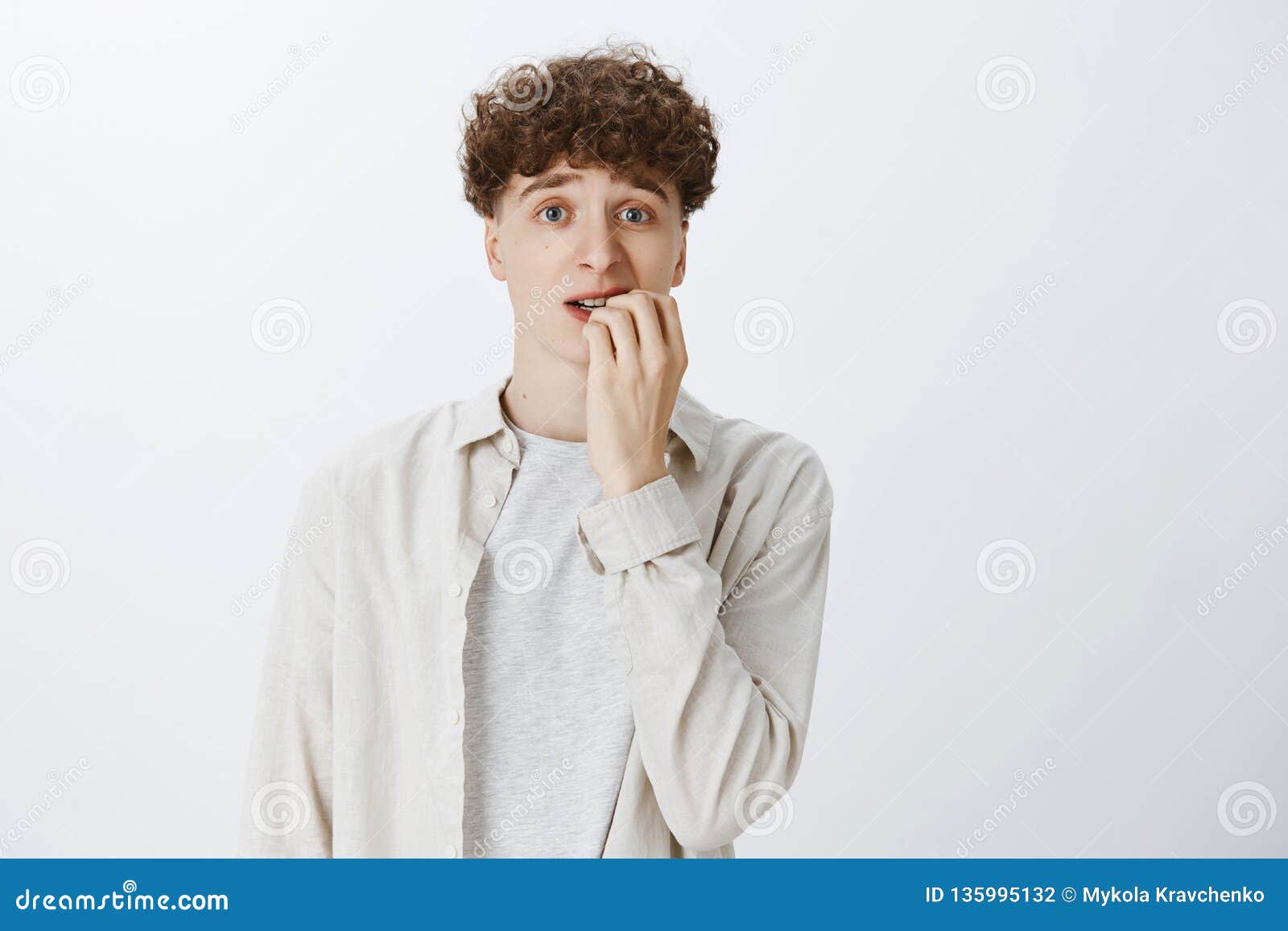 Anxious and Insecure Young Teenage Guy with Curly Hair in Shirt Biting  Fingernails Looking Unsure and Nervous As Stock Photo - Image of emotional,  handsome: 135995132