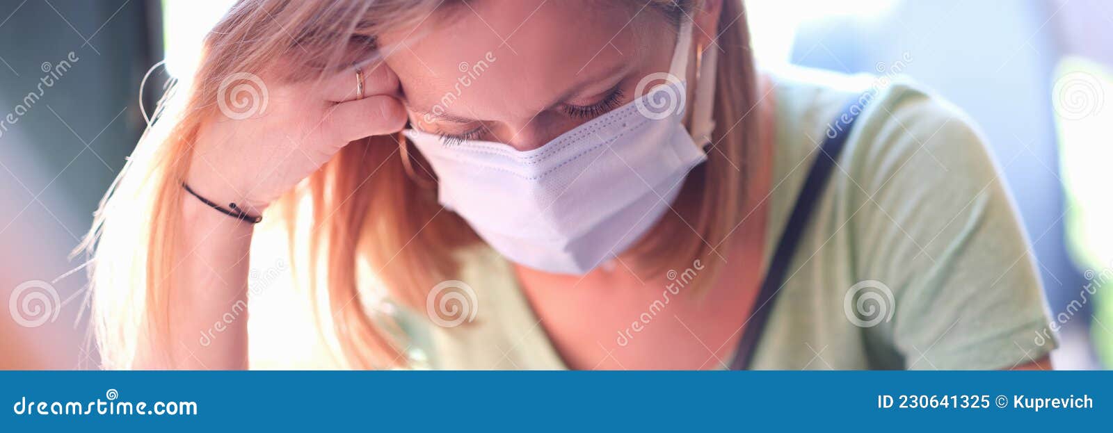 anxious sad woman in medical protective mask sits at table