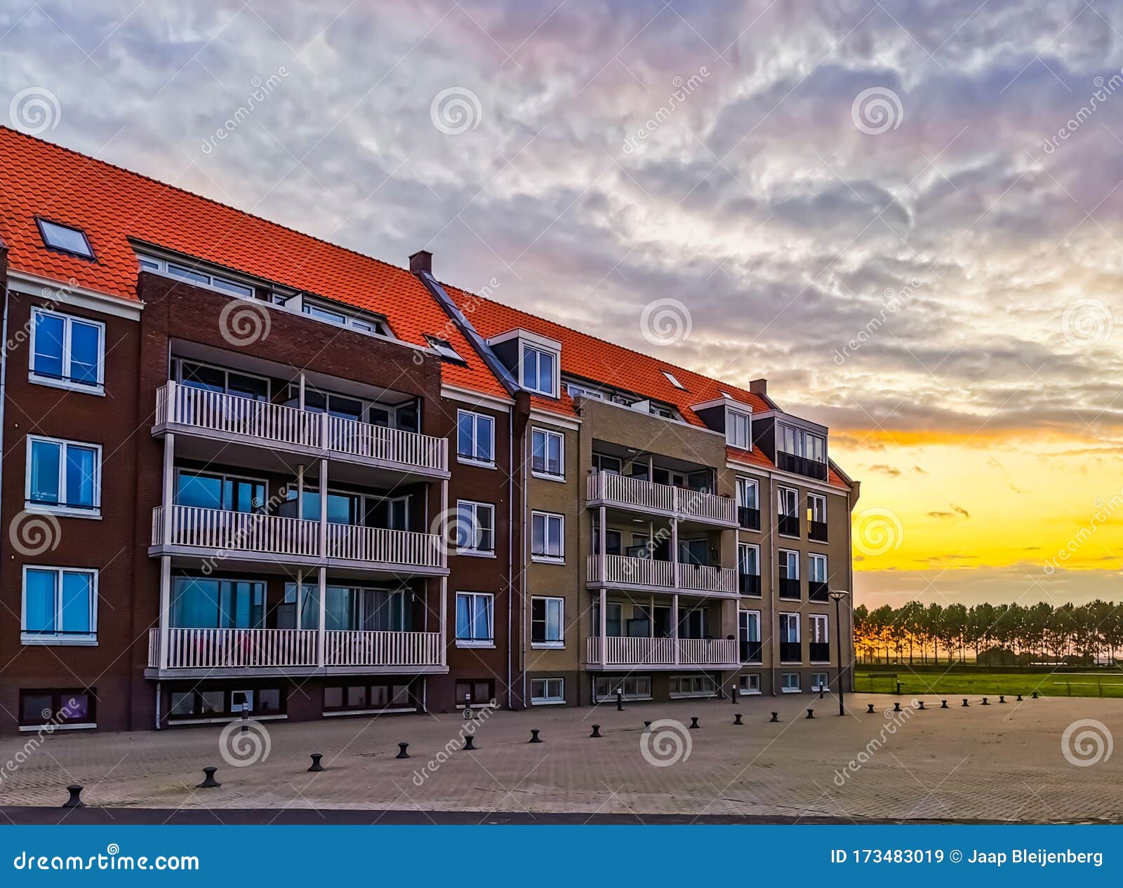 apartments building with the street during sunset in sint annaland, touristic town in zeeland, the netherlands