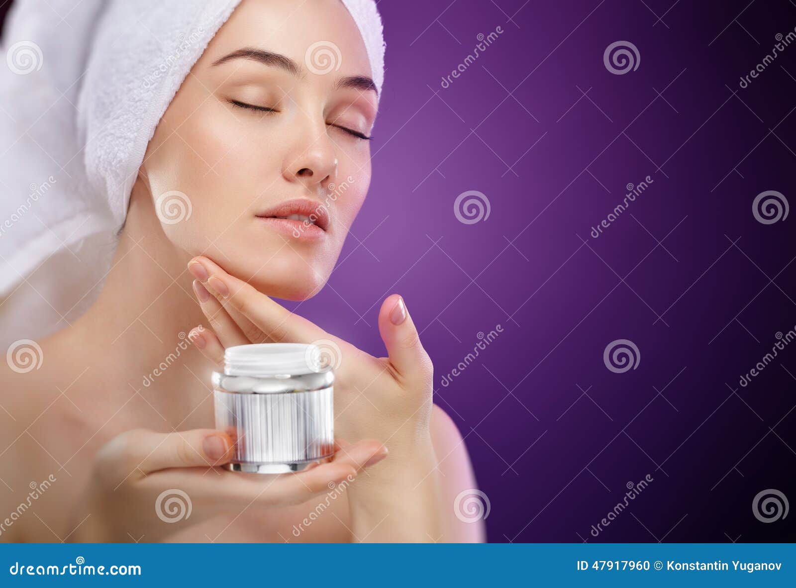 Aplicando o creme cosmético. Mulher bonita que aplica o creme cosmético