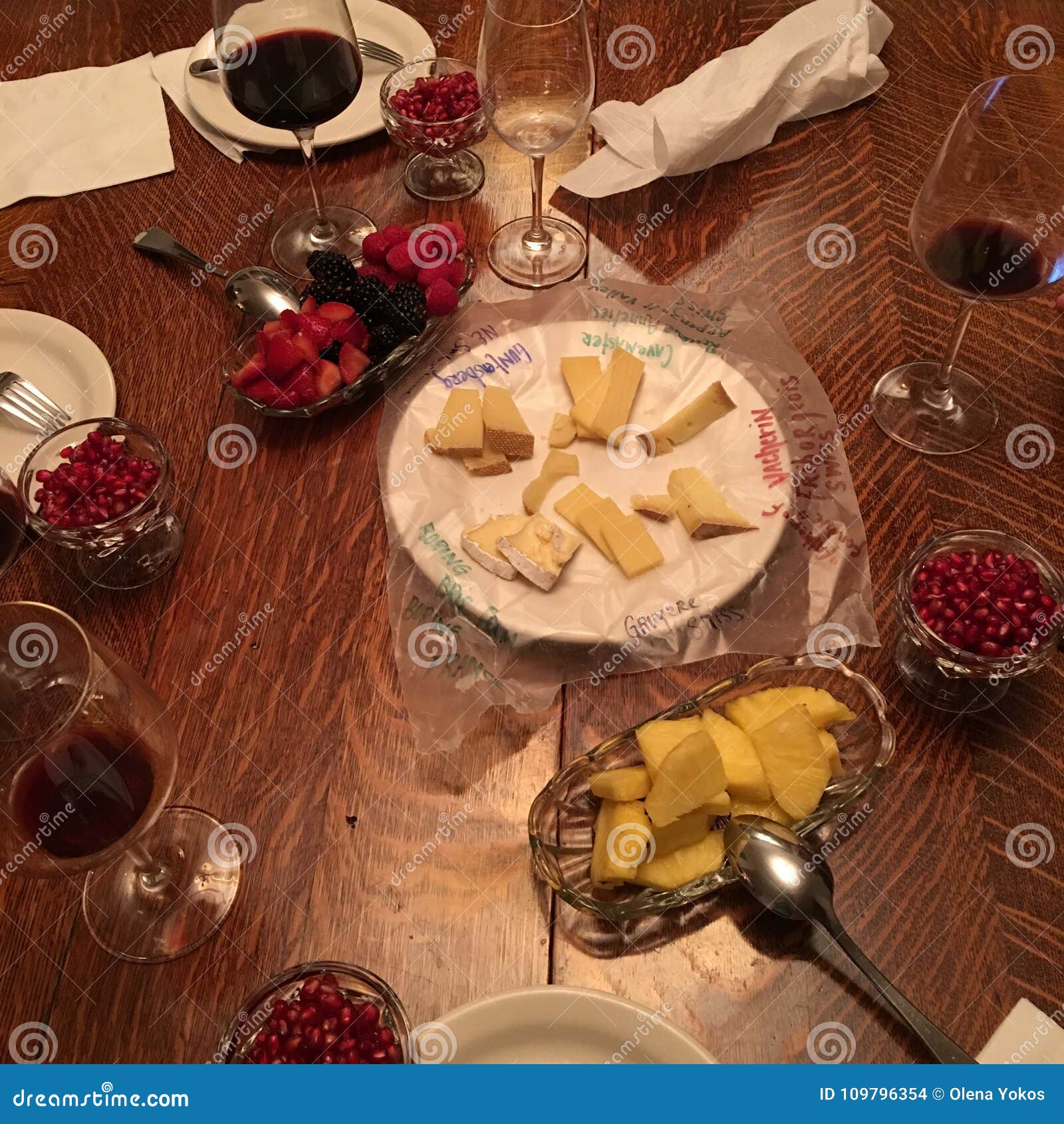 appetizing assortment of fresh cut up fruit and gourmet cheeses plate and wine - smorgasbord dining table setting high-angle view