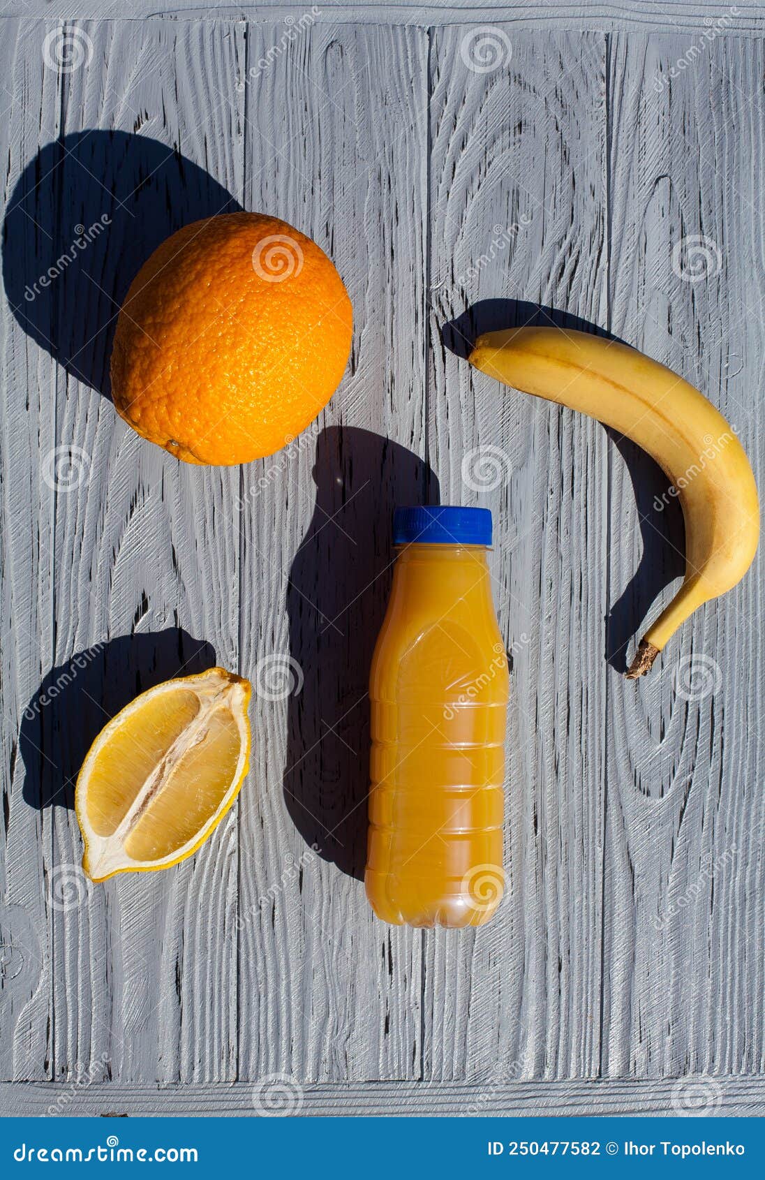 An Appetizing Composition of a Bottle of Orange Juice, Half a Lemon