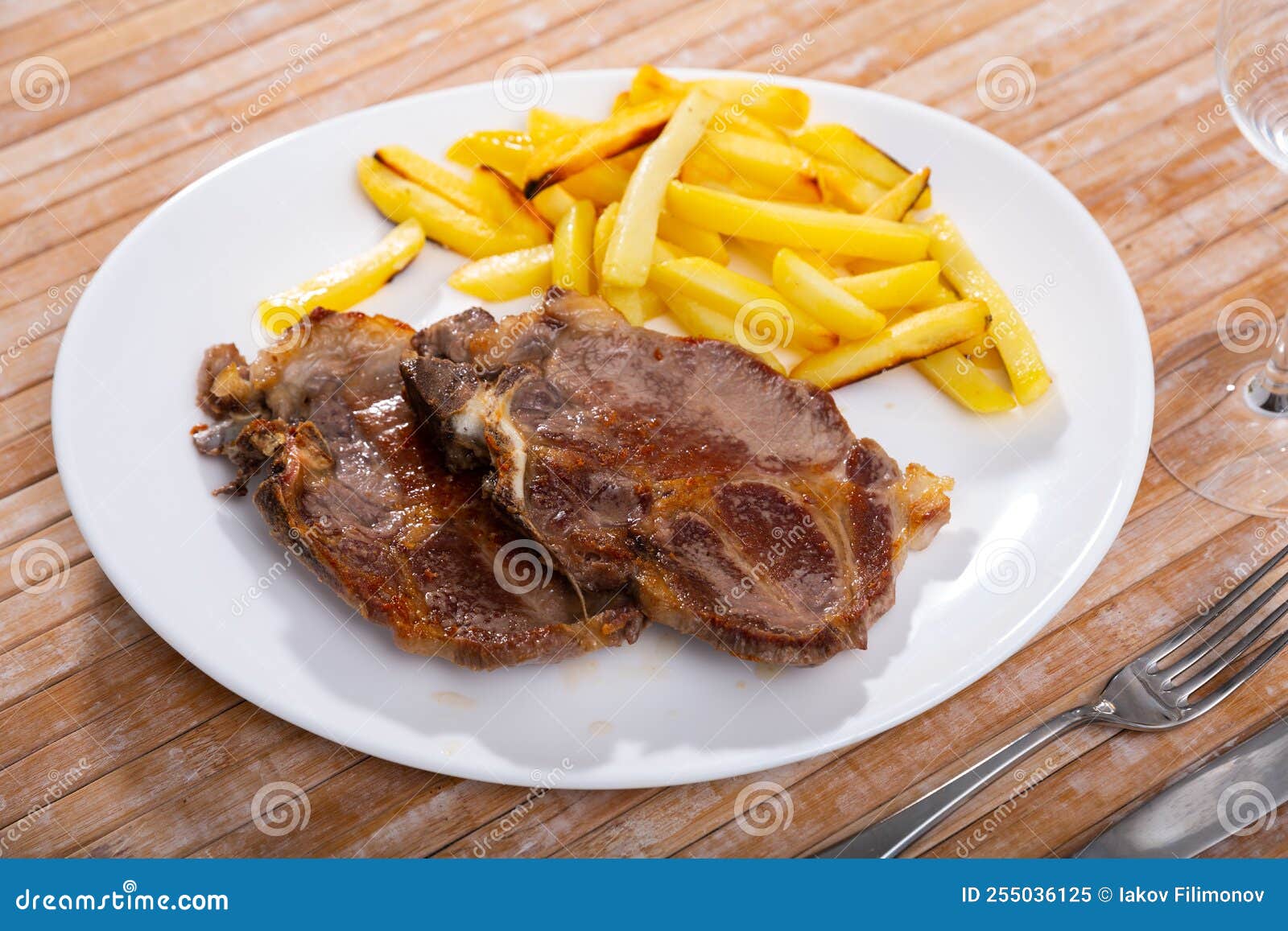 Roasted Bone-in Pork Chop with Crispy French Fries Stock Image - Image