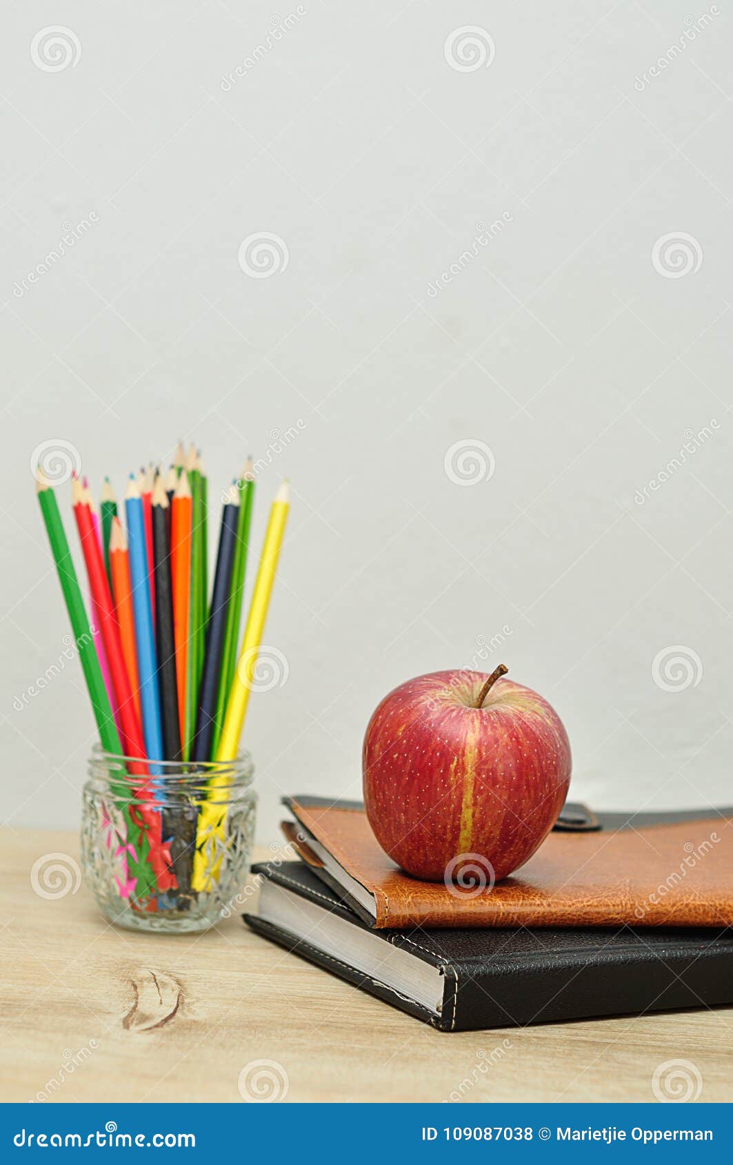 Download An Apple Displayed With Books And Coloring Pencils Stock Photo - Image of pencils, apple: 109087038