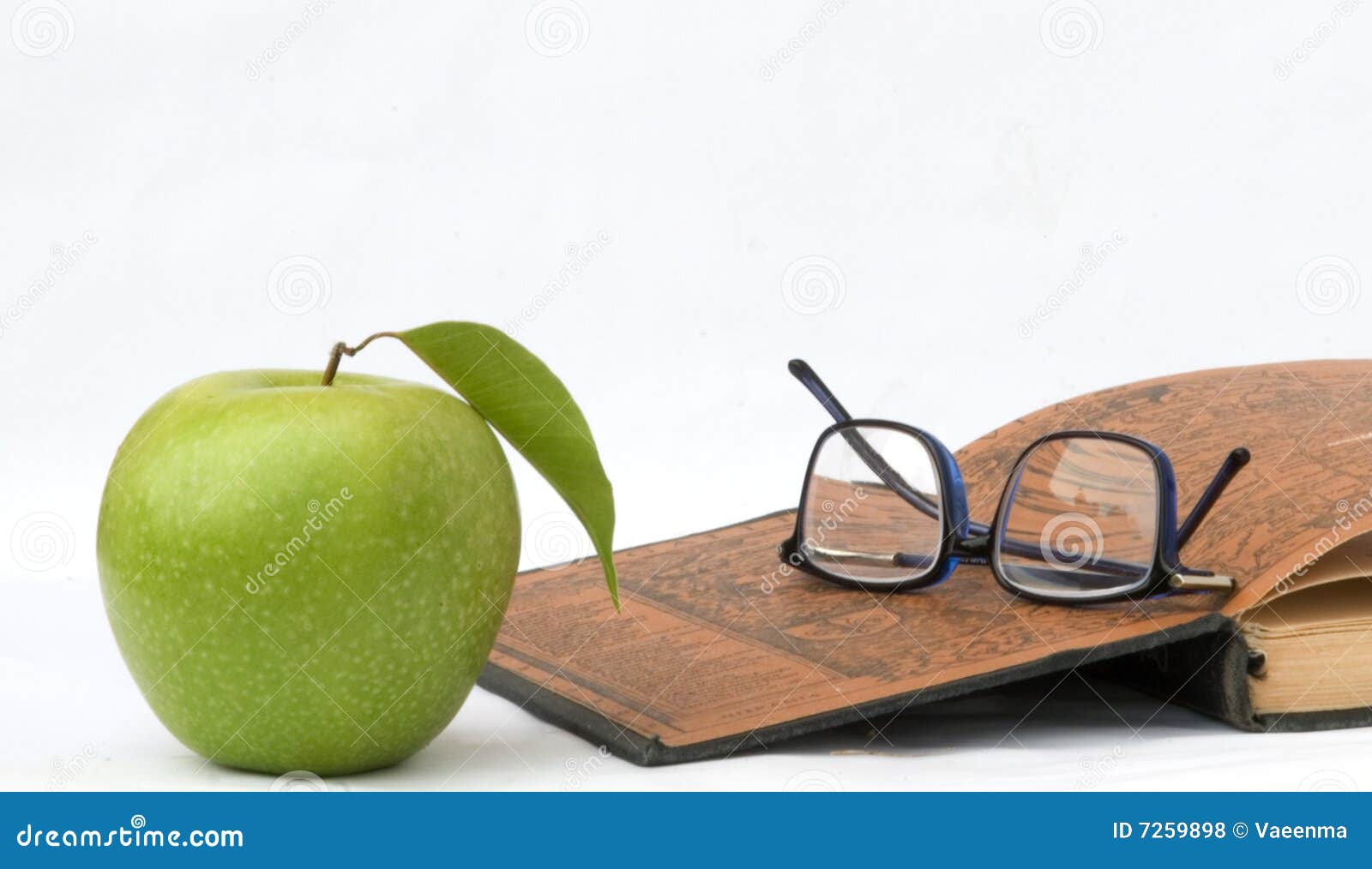 Apple, glasses and open book isolated on white background