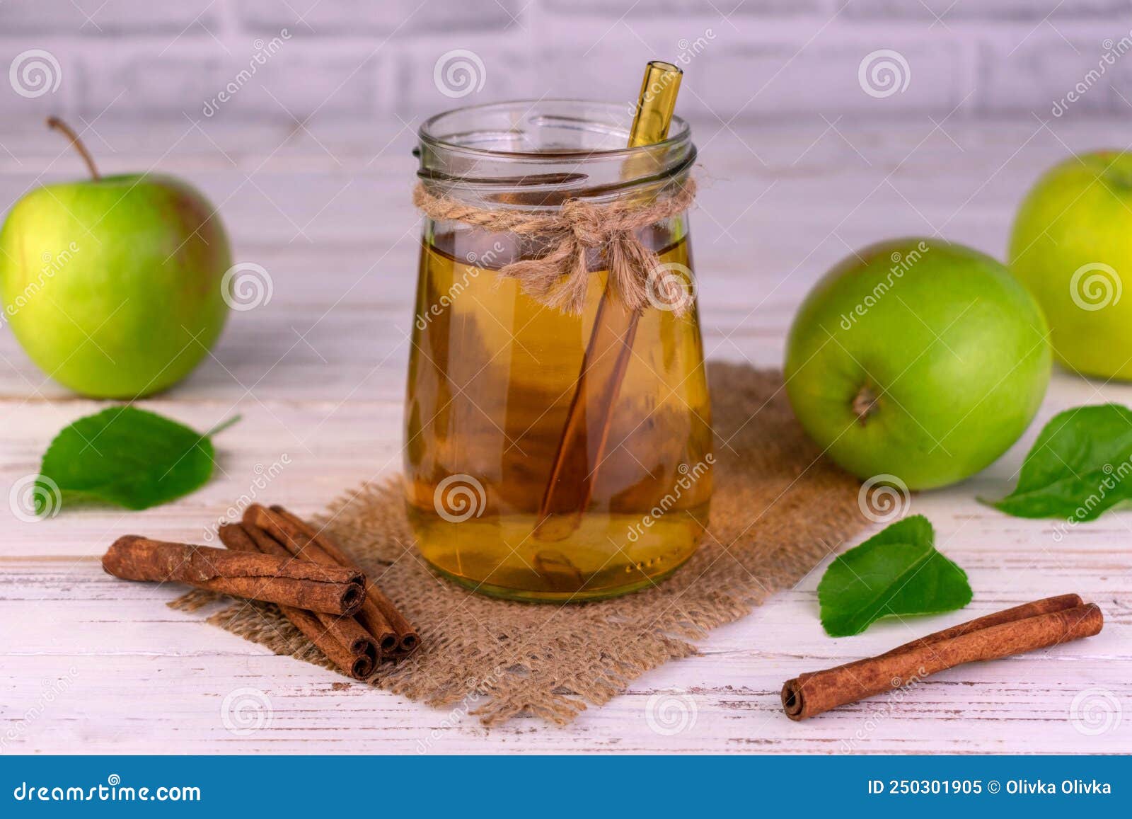 Apple Juice in a Jar and Fresh Green Apples with Cinnamon Sticks. Stock