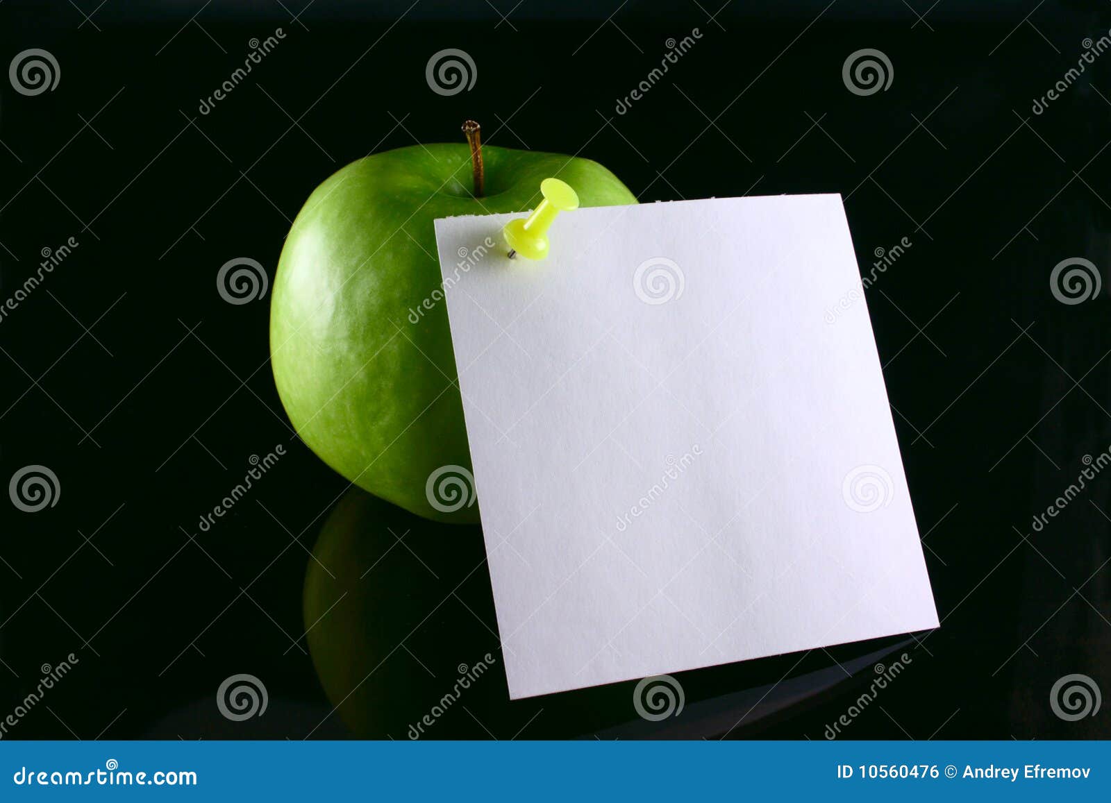 Apple on a note. Green apple with the pinned sheet of paper, removed on the blacked out glass