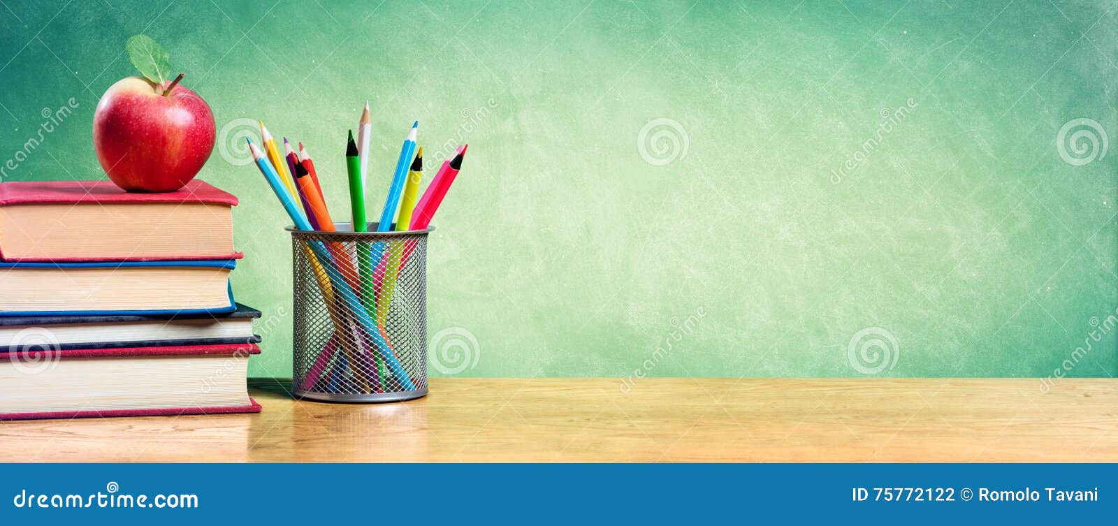 Apple on Stack of Books with Pencils and Blank Chalkboard Stock Photo