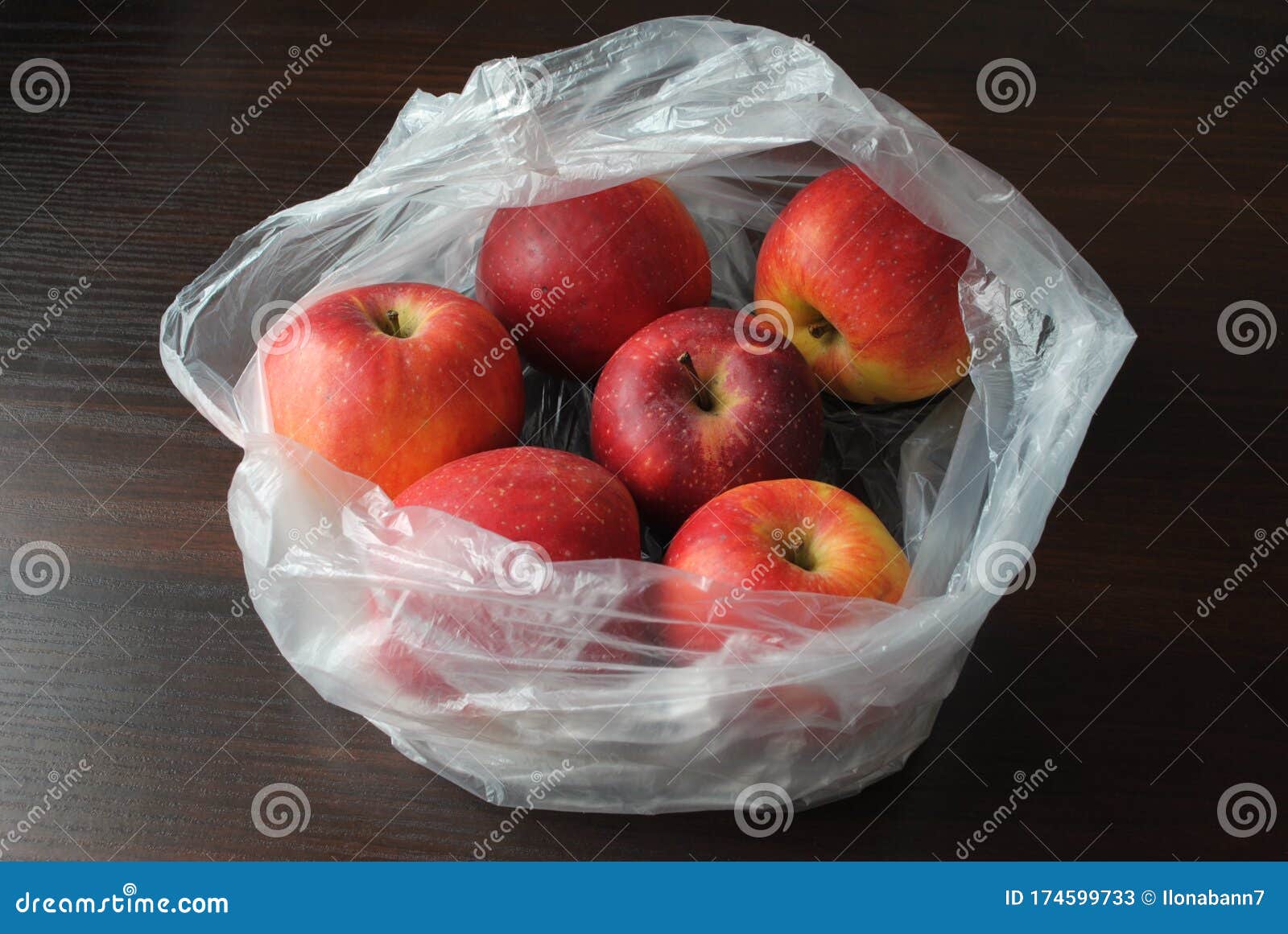 Apple fruit in plastic bag on wood table Stock Photo | Adobe Stock