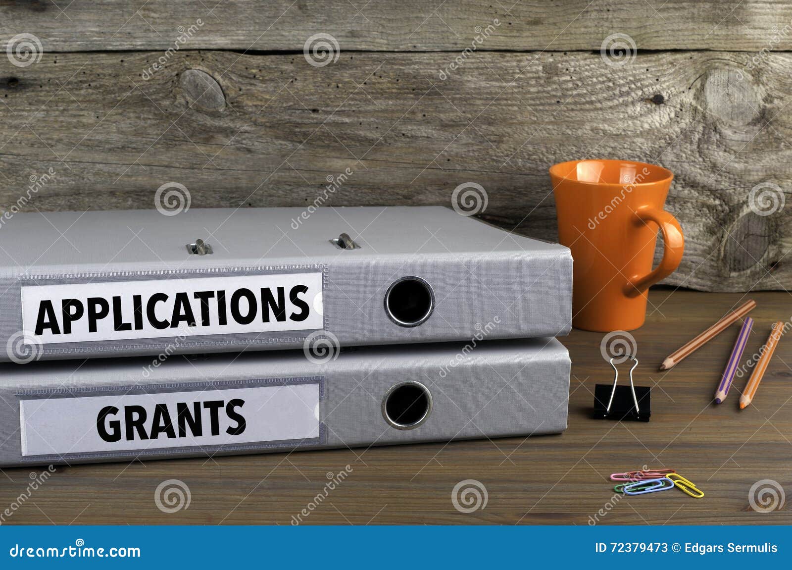 applications and grants - two folders on wooden office desk