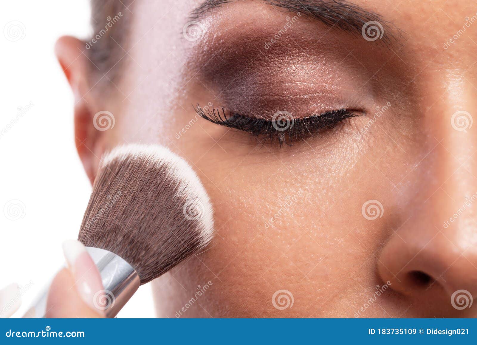 applying makeup on a face of a beautiful woman