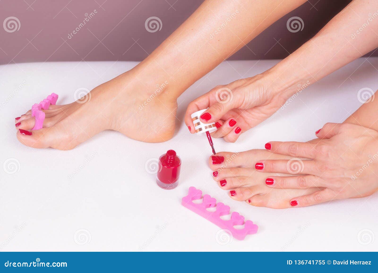 Applying Pedicure To Woman`s Feet with Red Toenails, in Pink Toe ...