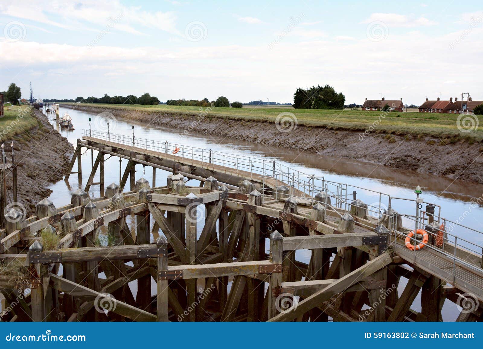 approach on river nene at low tide to crosskeys bridge at sutton