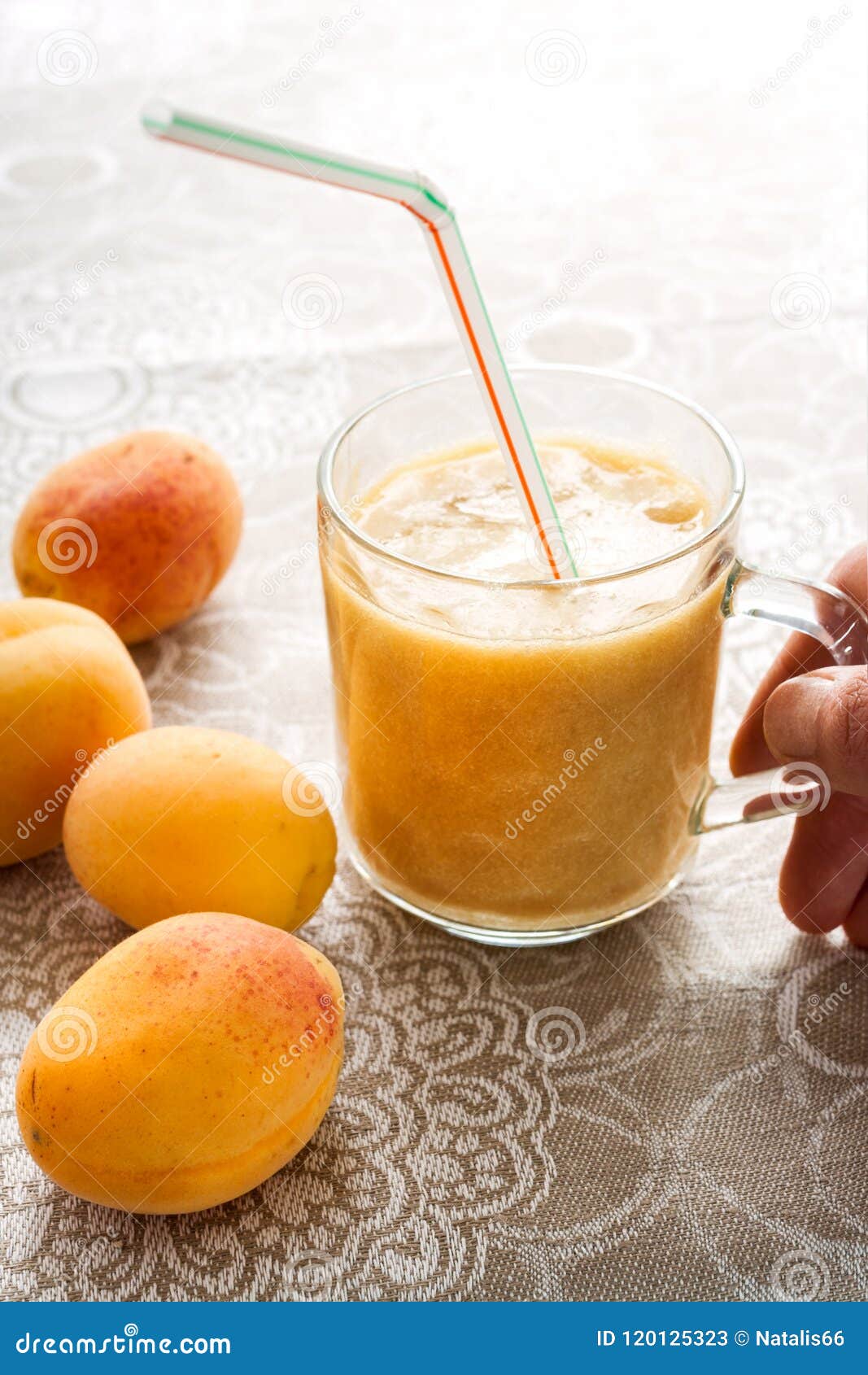 Apricots and Smoothie in Glass on Linen Tablecloth and Woman`s Hand ...