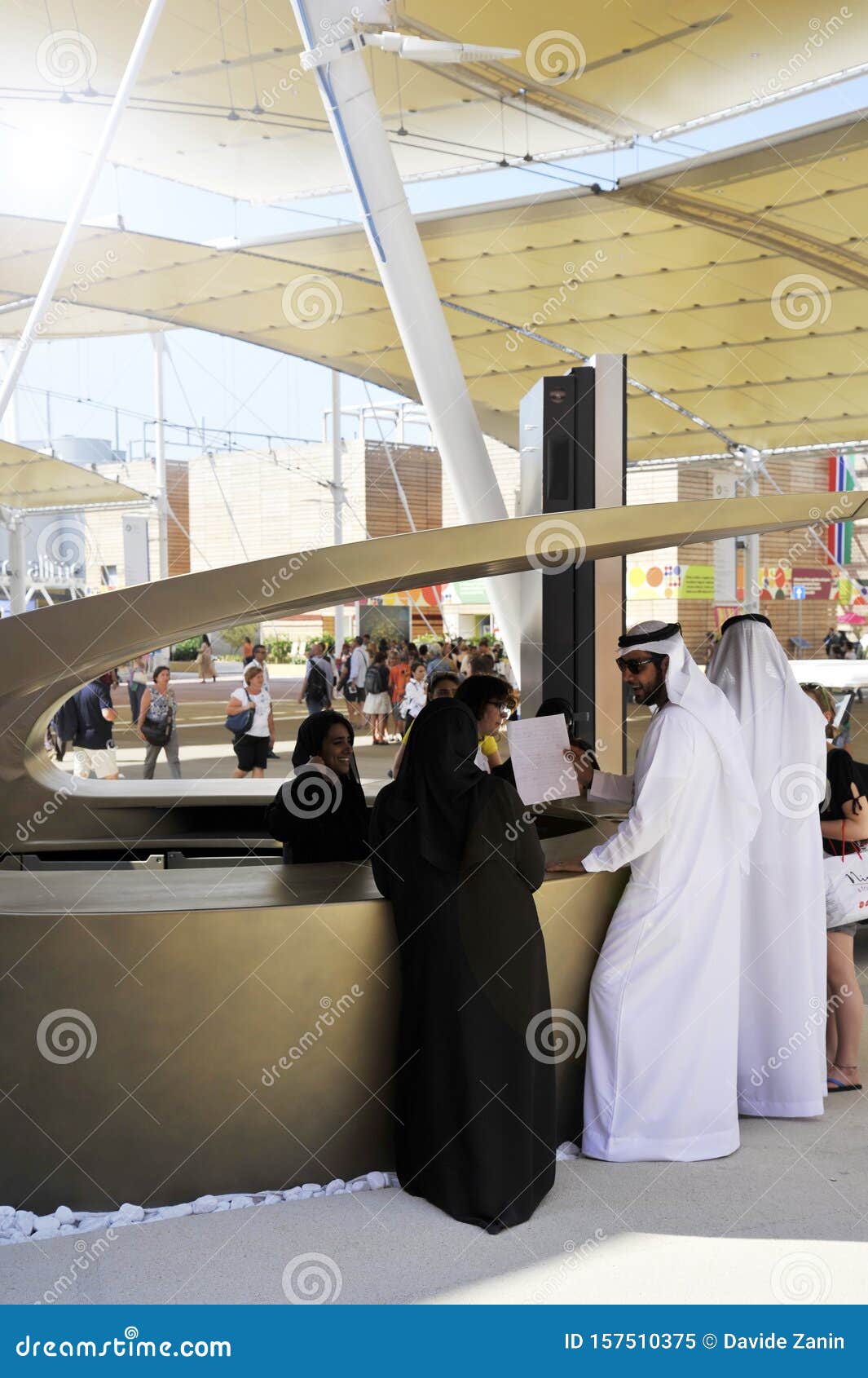 Arabian Female Receptionist Helping Smiling Customers On The Front