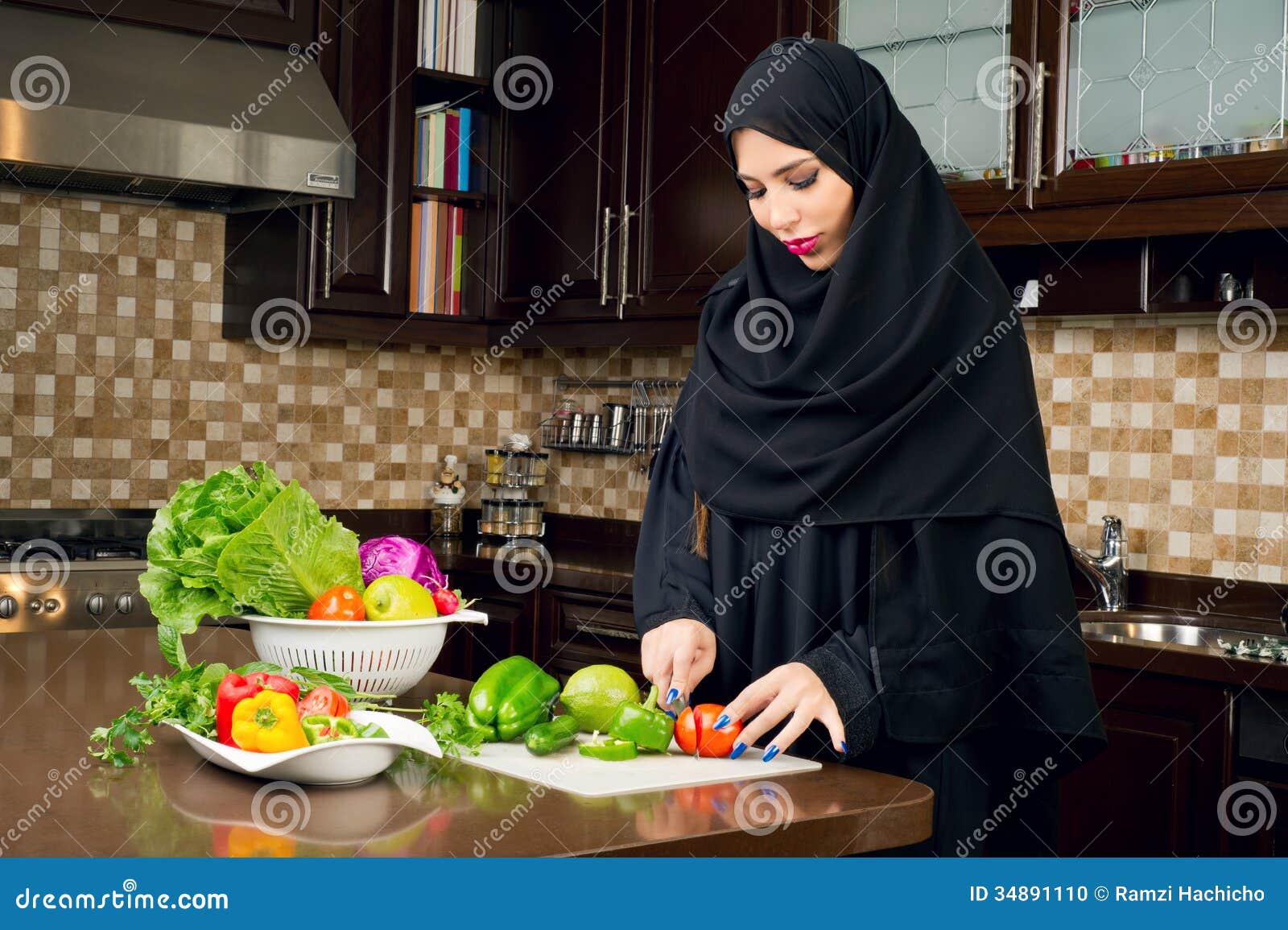 Arabian Woman Wearing Hijab Cutting Veggies In The Kitchen Arabian Woman Wearing Hijab Cutting Veggies In The Kitchen