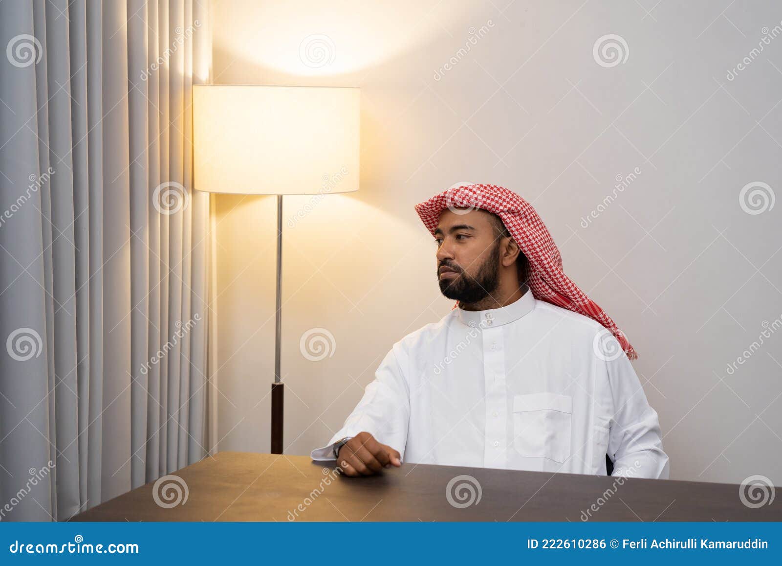 arabs in turbans look to the side while sitting behind a desk