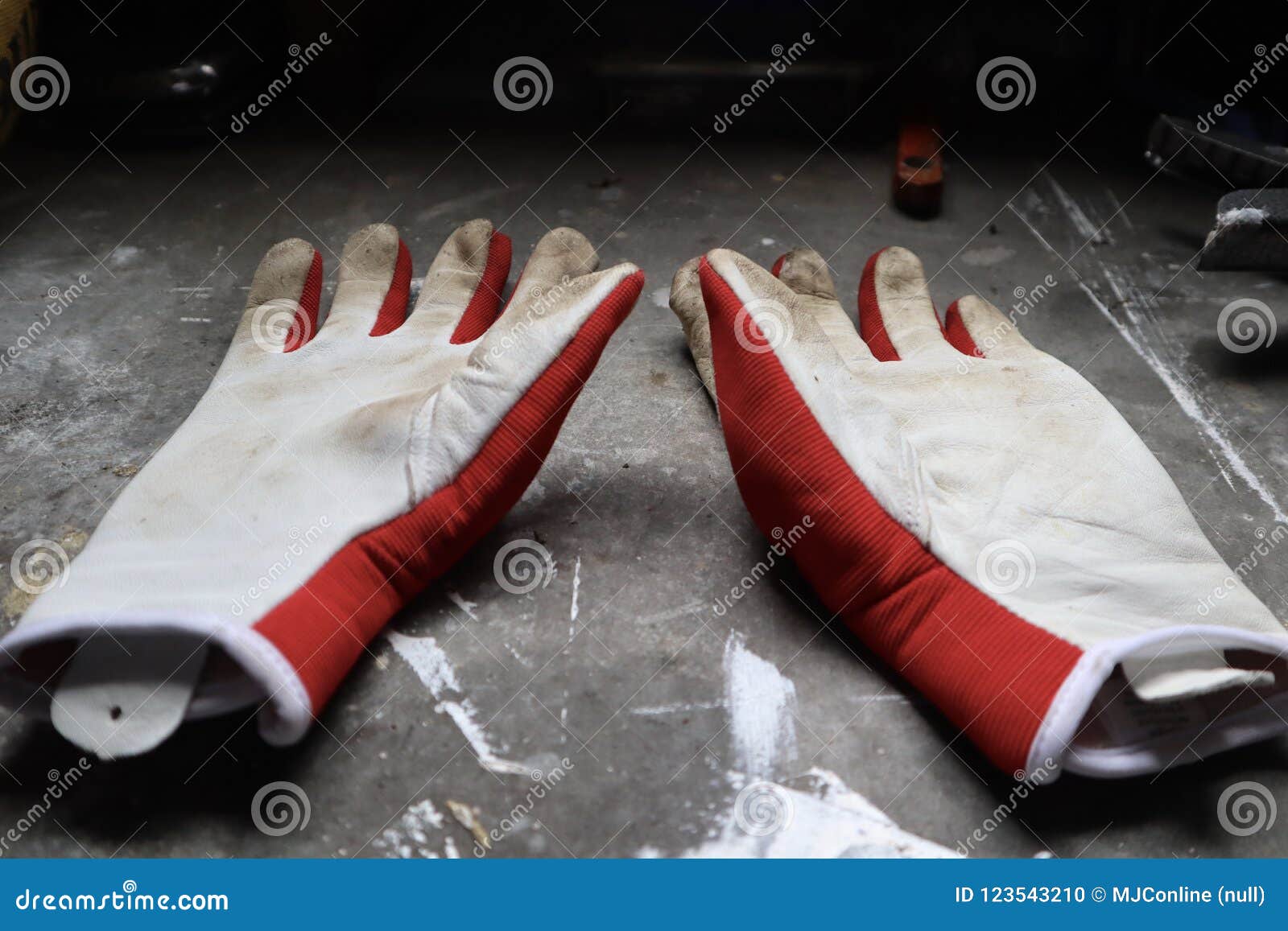 Arbeta i trädgården handskar på arbetsbänken. Rött och vit som arbeta i trädgården handskar på den industriella arbetsbänken i seminarium