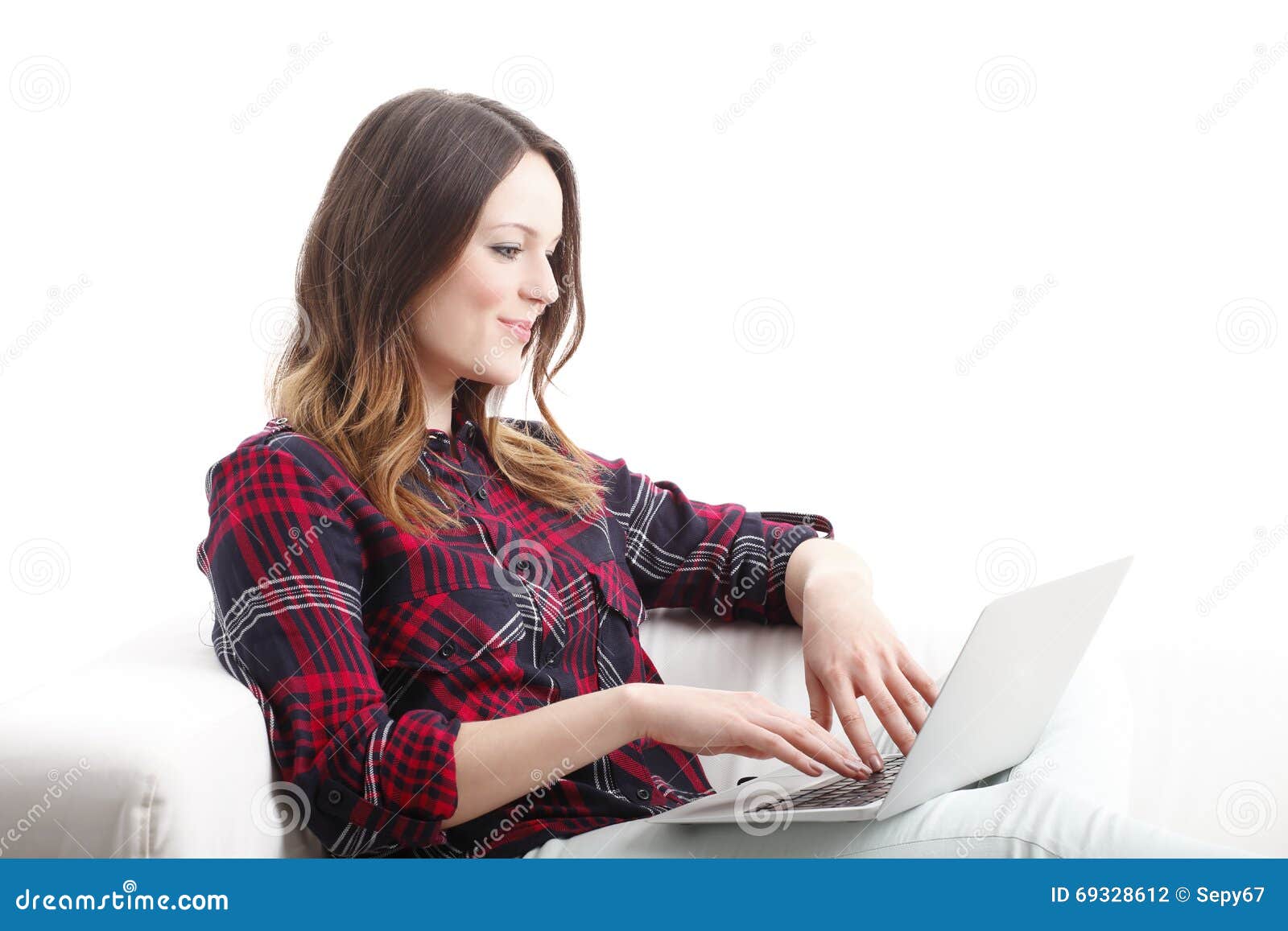 Arbete direktanslutet. Stående av den unga kvinnan med att arbeta för bärbar dator som är online-, medan sitta på soffan bakgrund isolerad white
