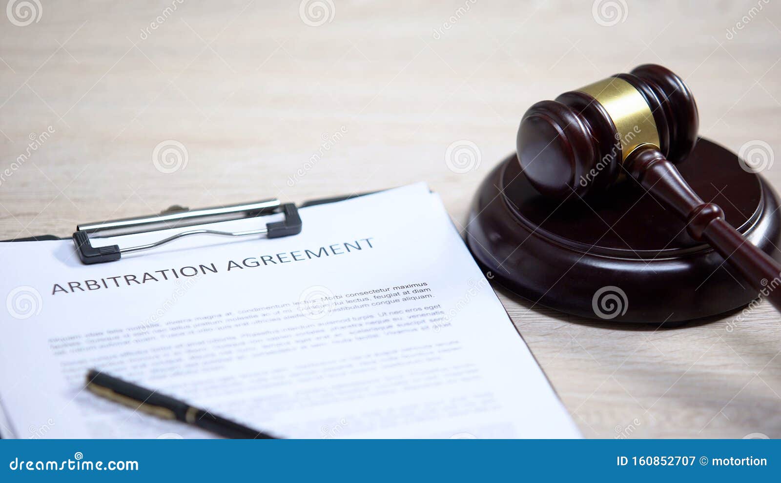 arbitration agreement document on table, gavel lying on sound block, dispute