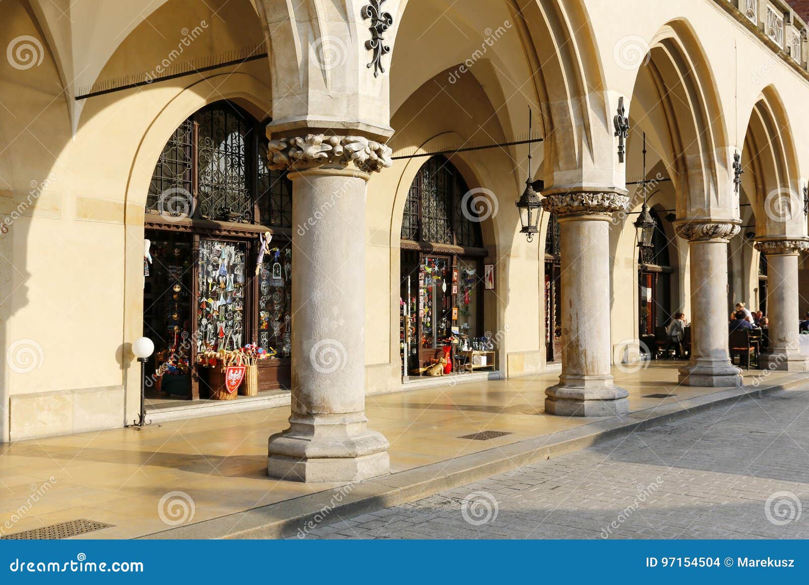 Arcades van de Doekzaal in Krakau. Krakau, Polen - Mei 25, 2017: Arcades, een deel van de Doekzaal op het oude stadsvierkant Er zijn opslagvensters en een paar mensen in een afstand kunnen worden gezien