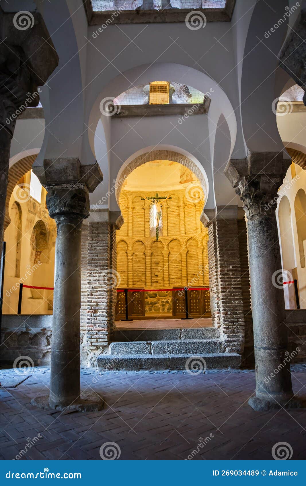 arch and columns and a cross with a christ inside a muslim mosque in toledo