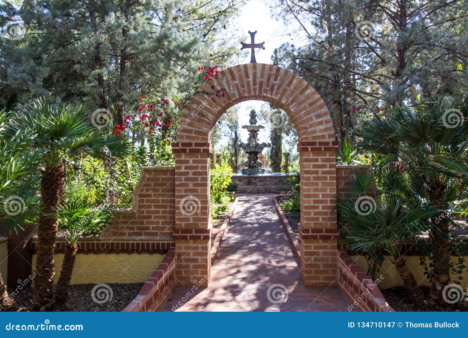 Arch with Cross Leading To Fountain in Monastery Garden Stock Image