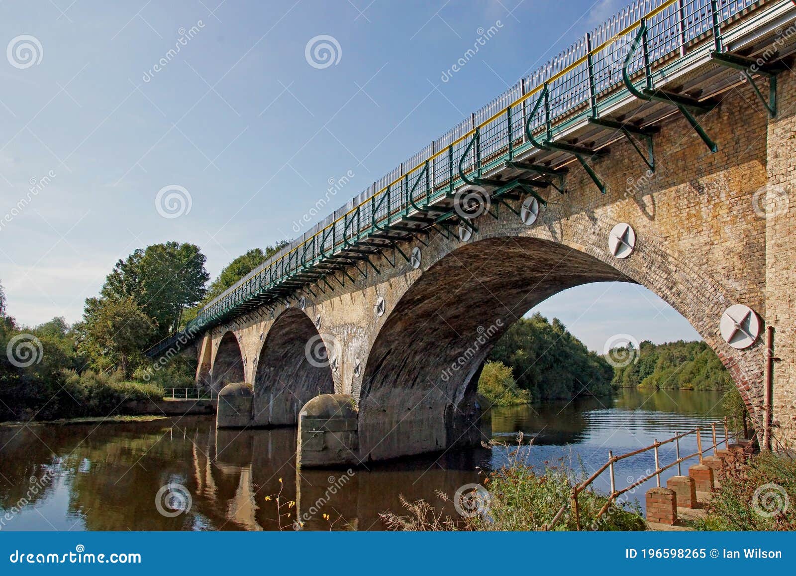 arched railway bridge viaduct over a river in summer