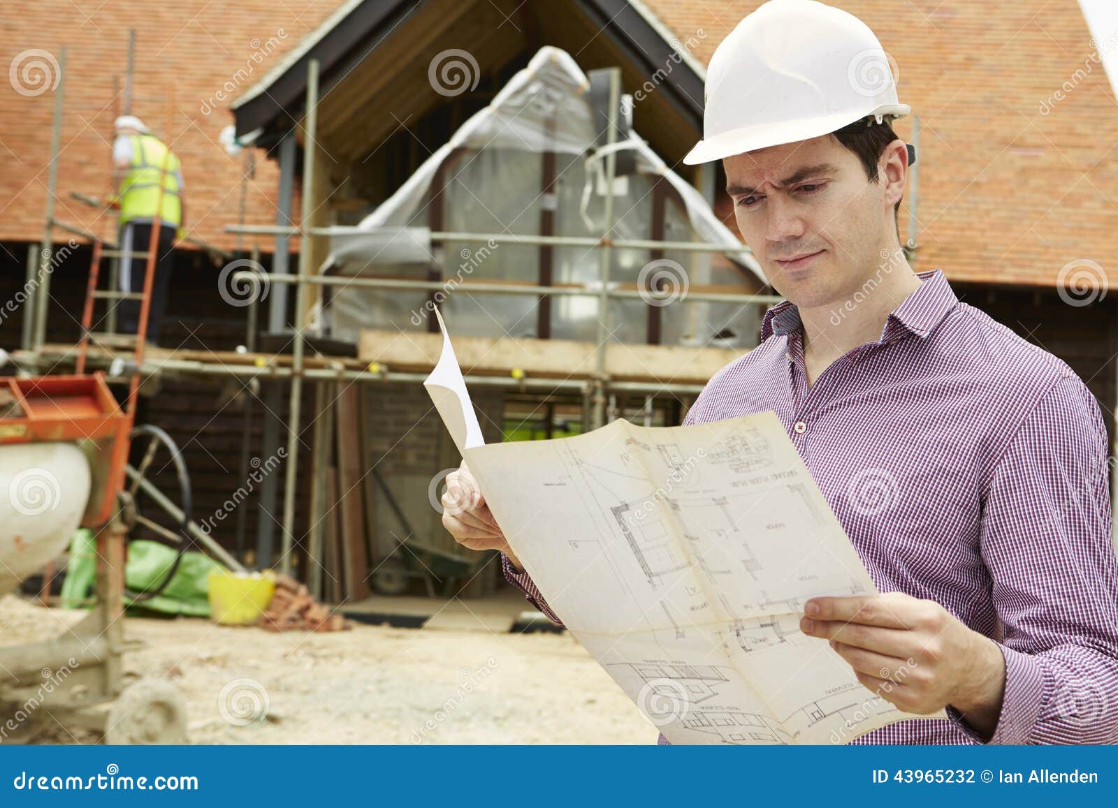 architect on building site looking at house plans