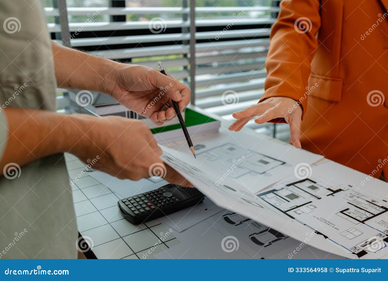 an architect and engineer work as a team, an engineer is discussing with coworker about detail of house model compare with