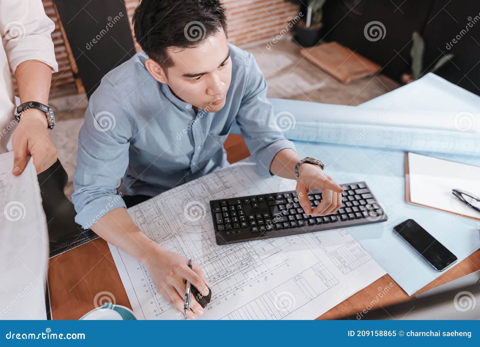architect reading building and  drawing outlay construction plan as guide for builders with details on computer. engineer 