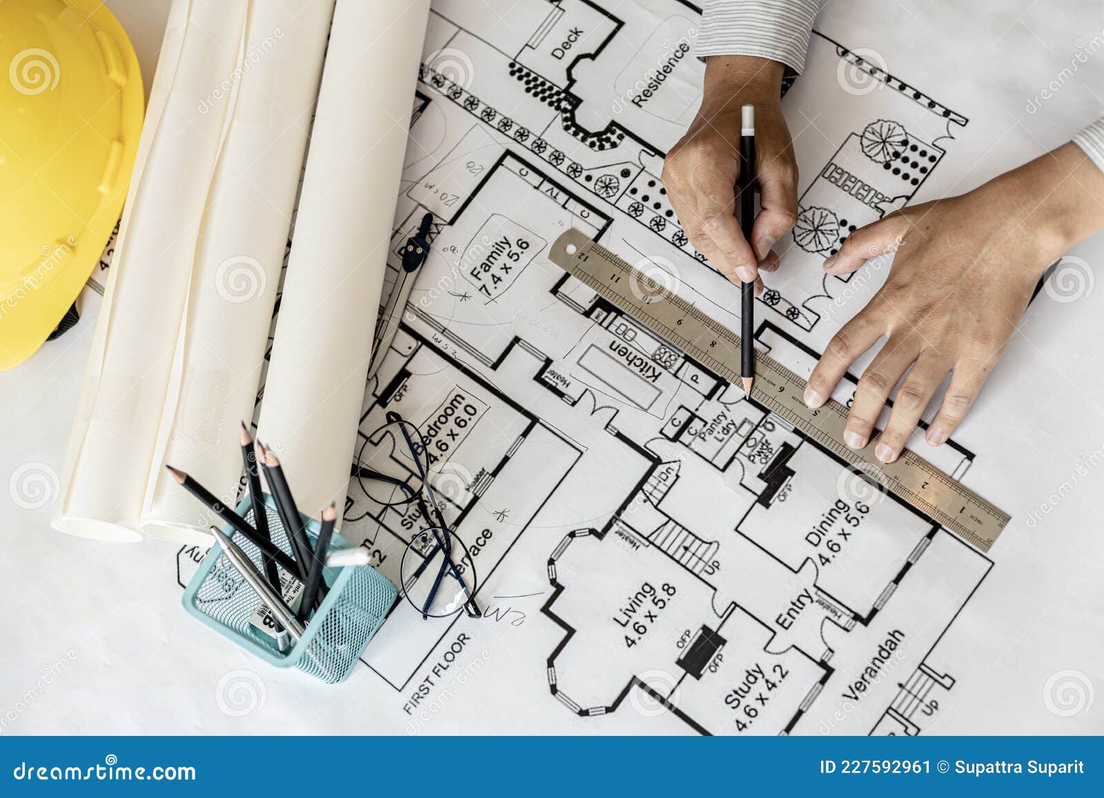 Architect Uses A Ruler To Measure The Blueprints Of The Houses He