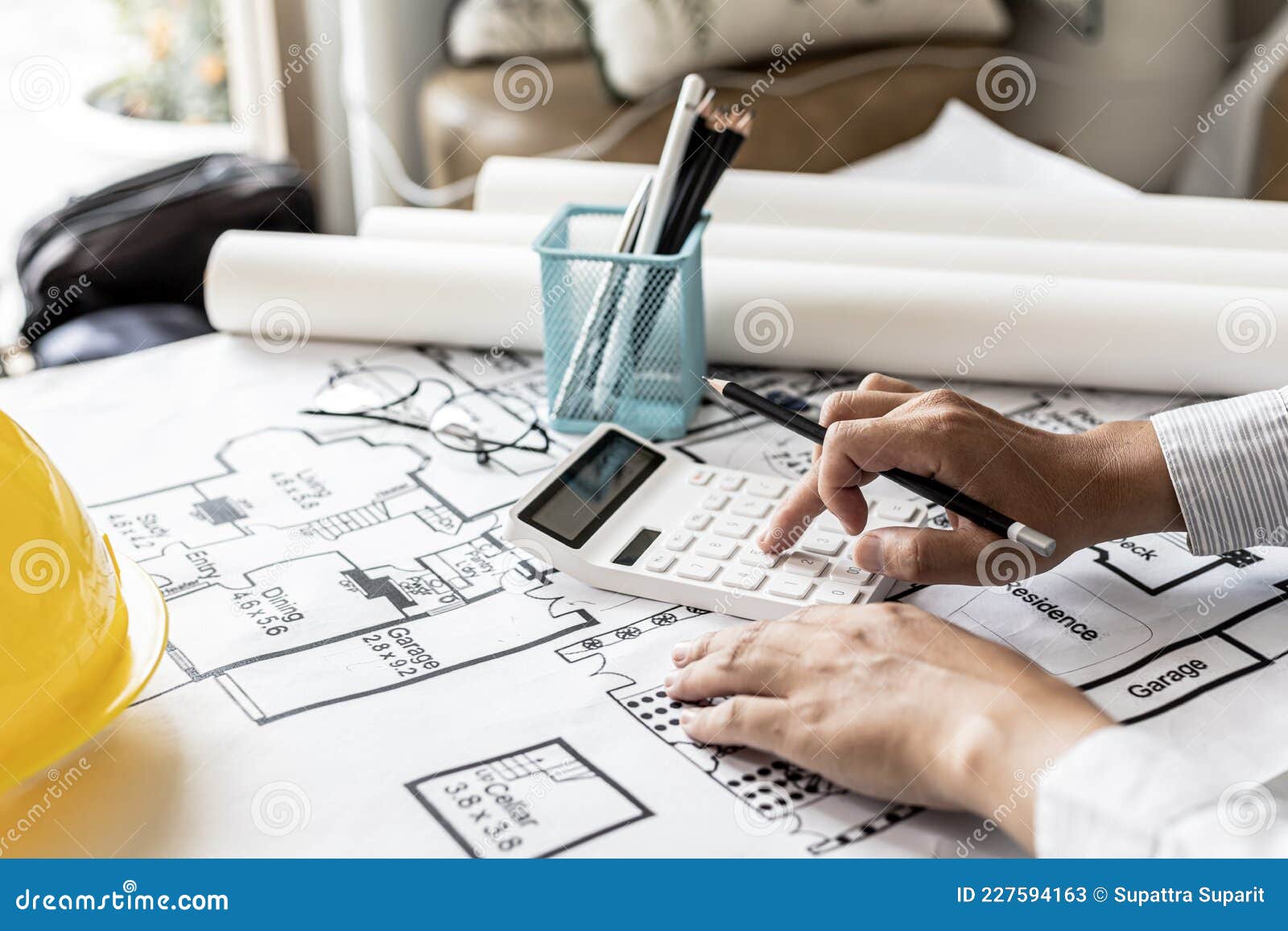the architects pressed a calculator to calculate the area in a blueprint, ing the house according.