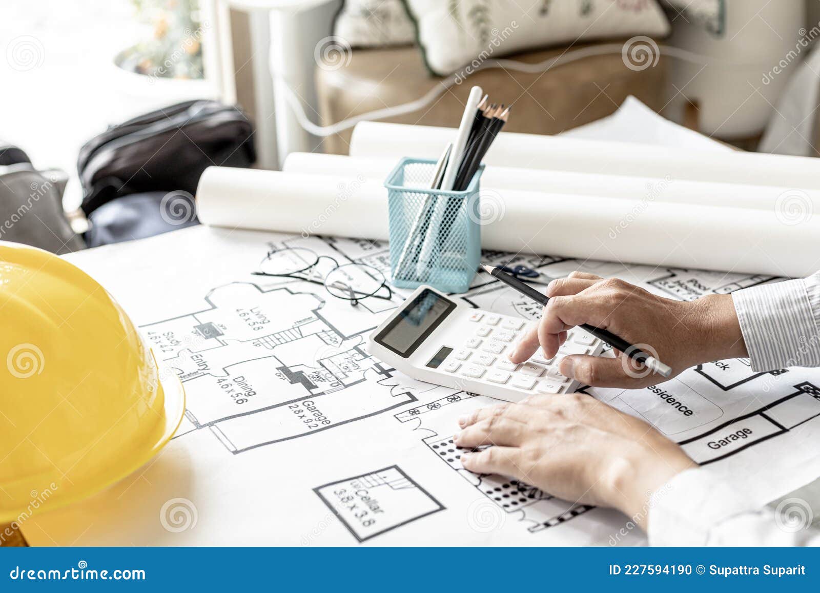 the architects pressed a calculator to calculate the area in a blueprint, ing the house according.