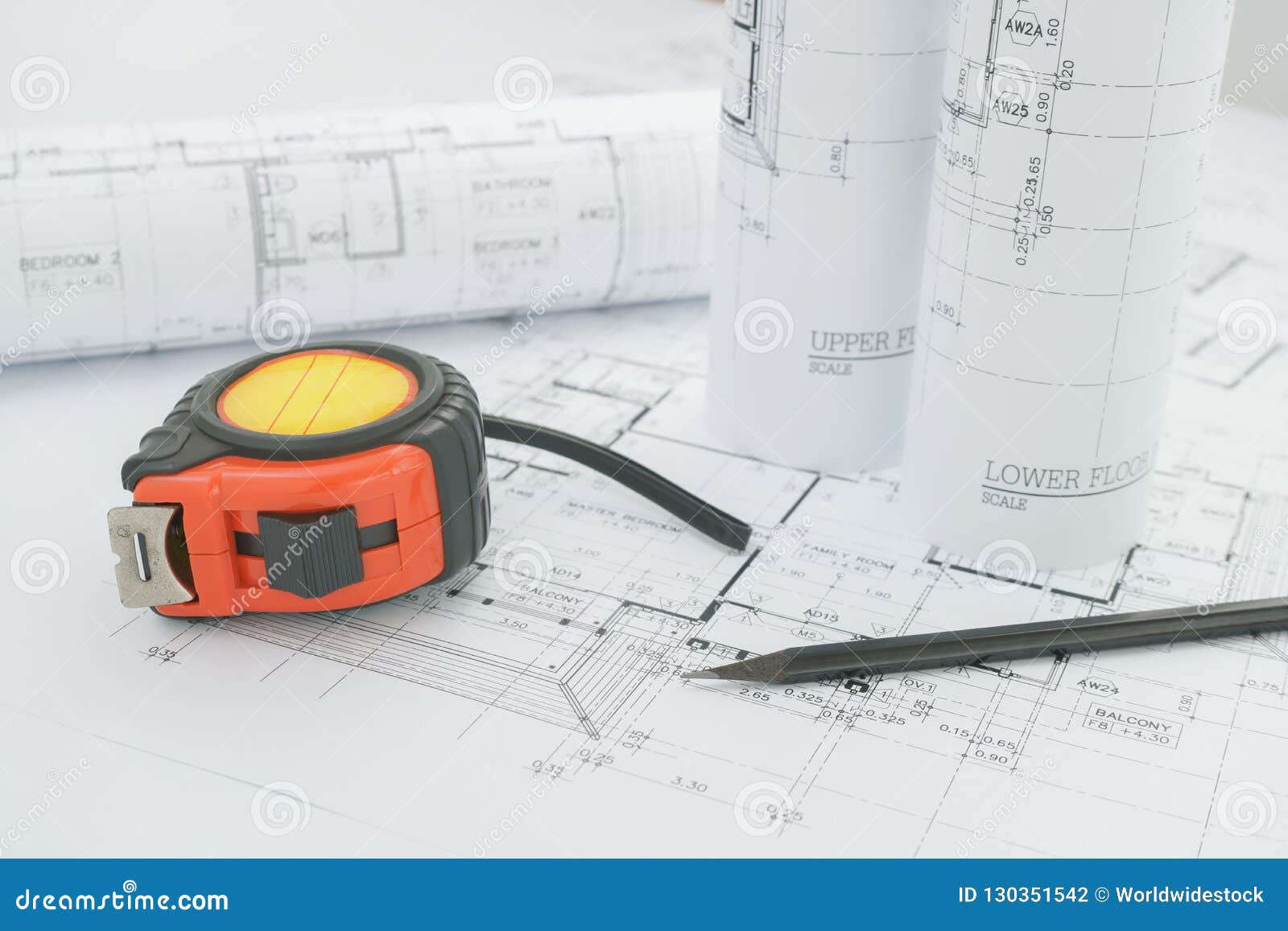 Architectural Blueprints with Measuring Tape and Black Pencil on Table