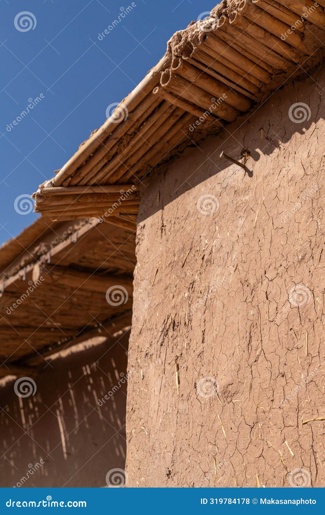 architectural detail of an earthen clay adobe wall and roof in a village in the moroccan desert