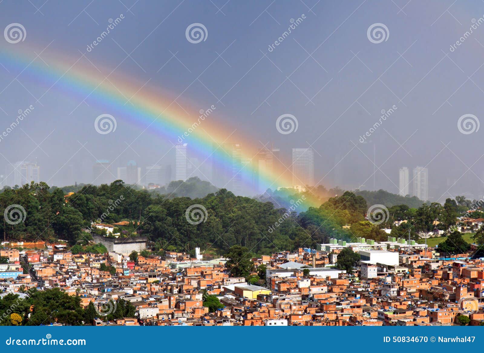 Arco iris sobre Sao Paulo, el Brasil. Arco iris sobre los tugurios de Paraisopolis en cementerio de Sao Paulo, el Brasil Morumbi en la derecha Sepulcro de Ayrton Sanna Edificios de oficinas en fondo En febrero de 2015