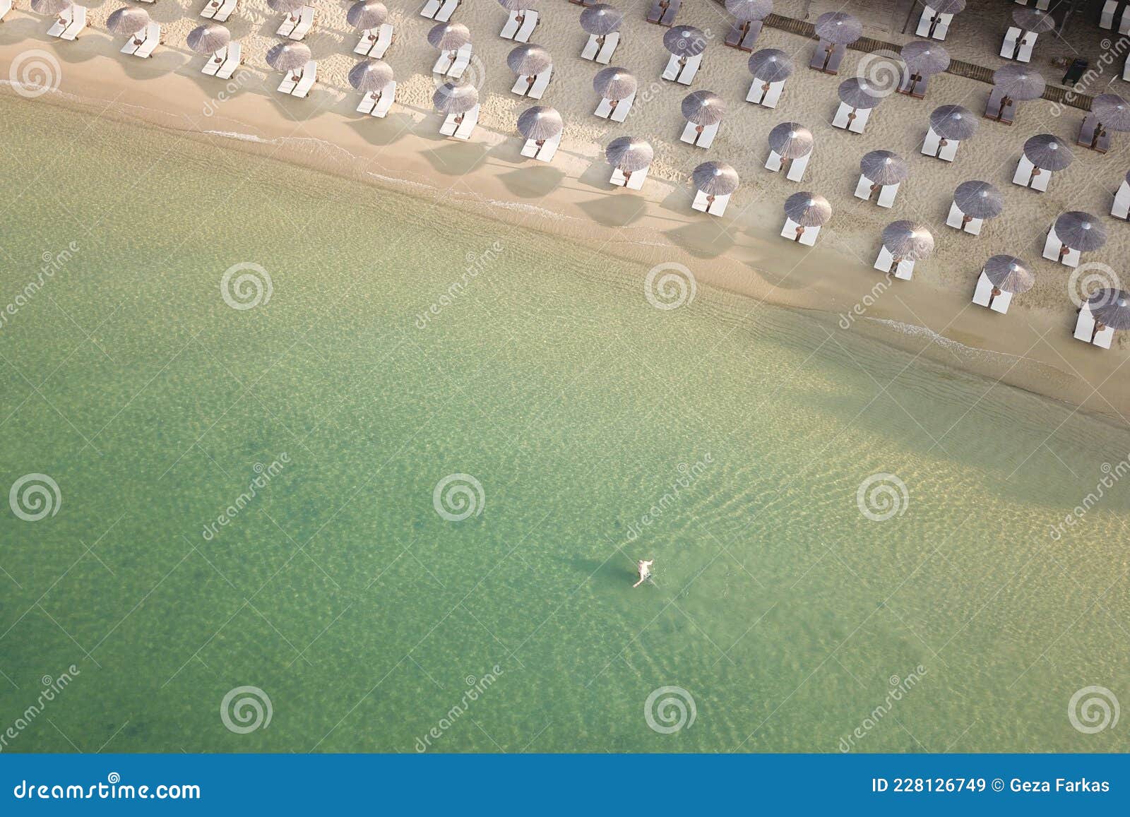 areal view of sandy koukounaries beach, turquoise sea, parasols and sunbeds