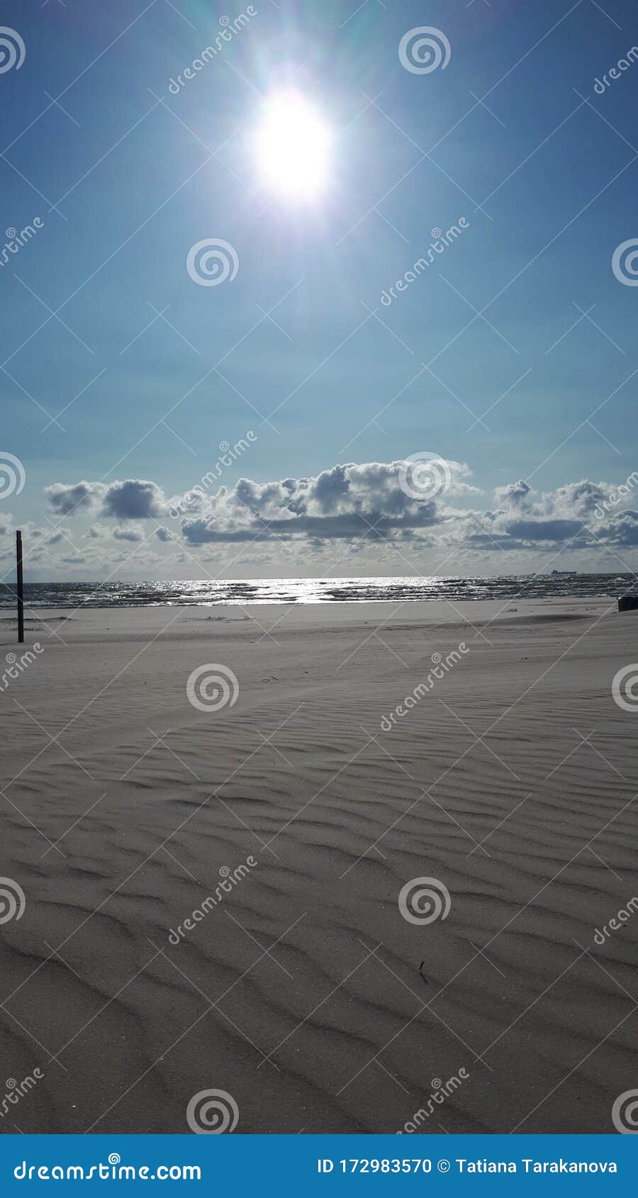 Arena Infinita Y Un Mar Húmedo Bajo El Ardiente Sol Foto de archivo