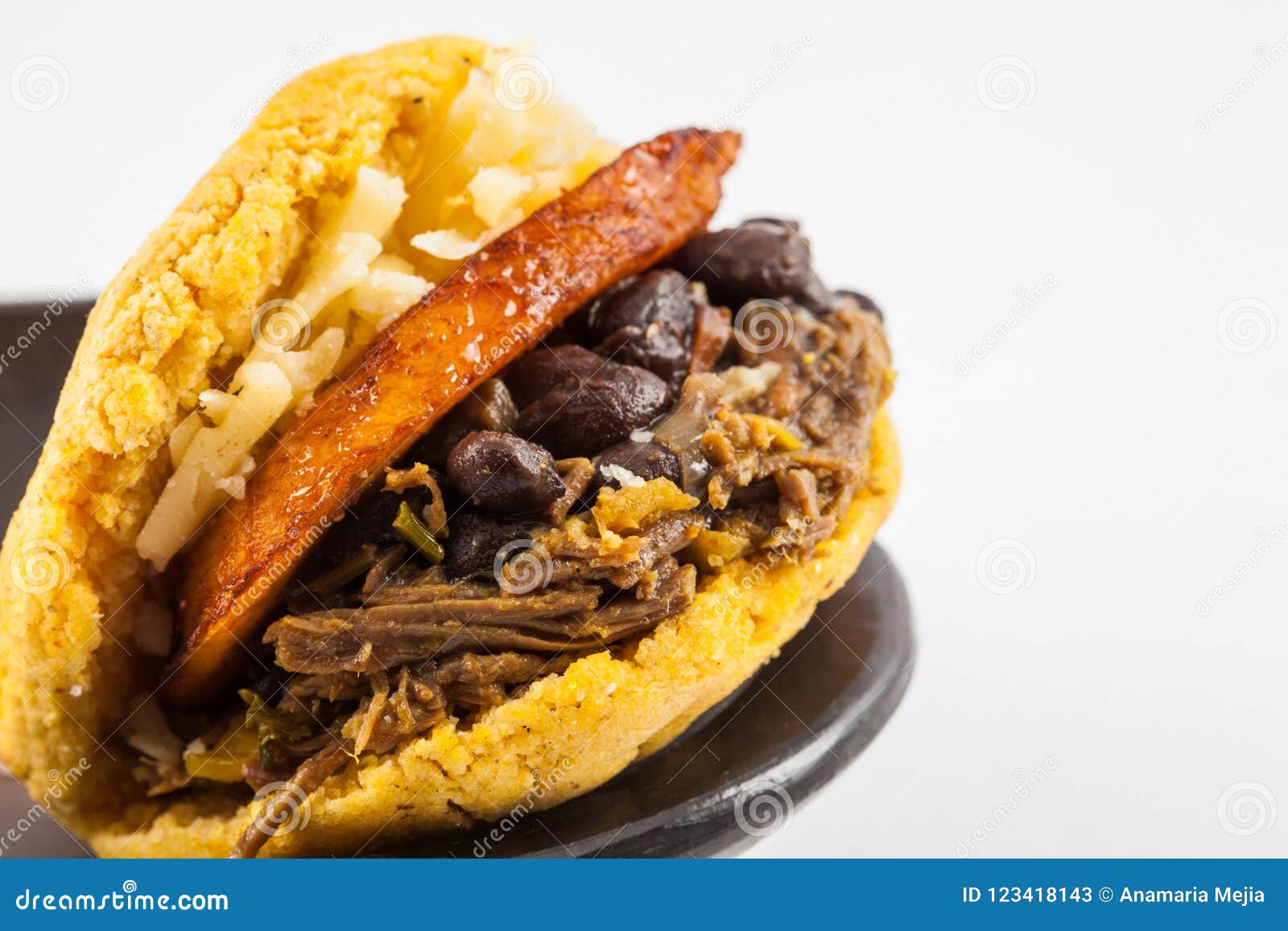 https://thumbs.dreamstime.com/z/arepa-llen%C3%B3-de-la-carne-vaca-las-alubias-negras-del-llant%C3%A9n-destrozado-y-queso-servidos-en-un-plato-cer%C3%A1mica-negro-123418143.jpg