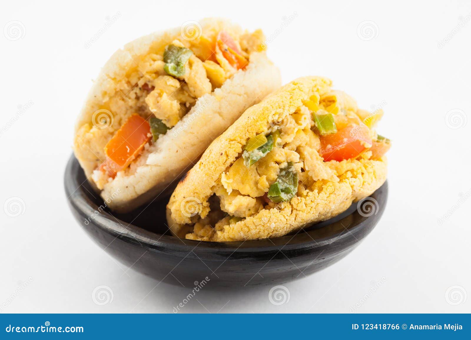 Arepas Filled with Scrambled Eggs Served in a Black Ceramic Dish Stock